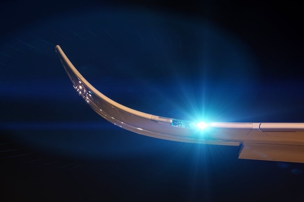 An aircraft wing, with a single light shining.