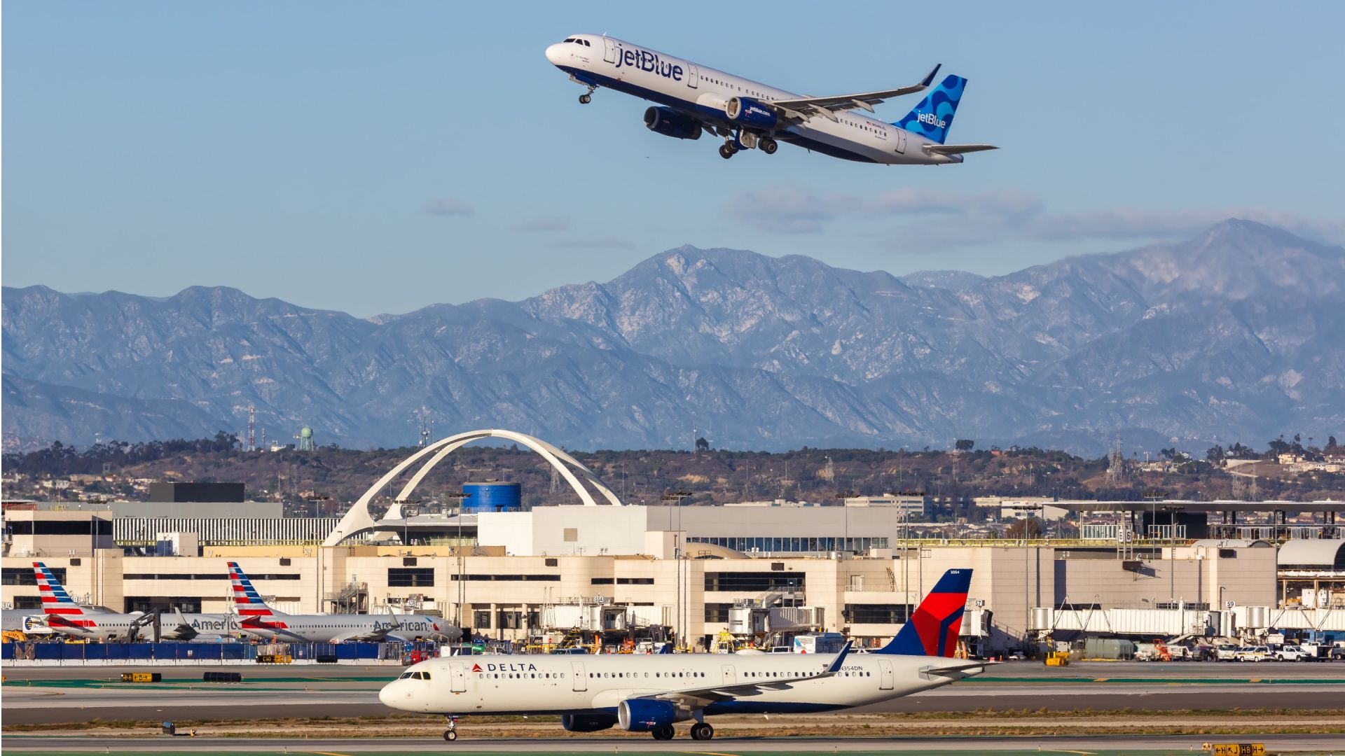 American Airlines, Delta Air Lines, and JetBlue aircraft at Los Angeles International Airport.