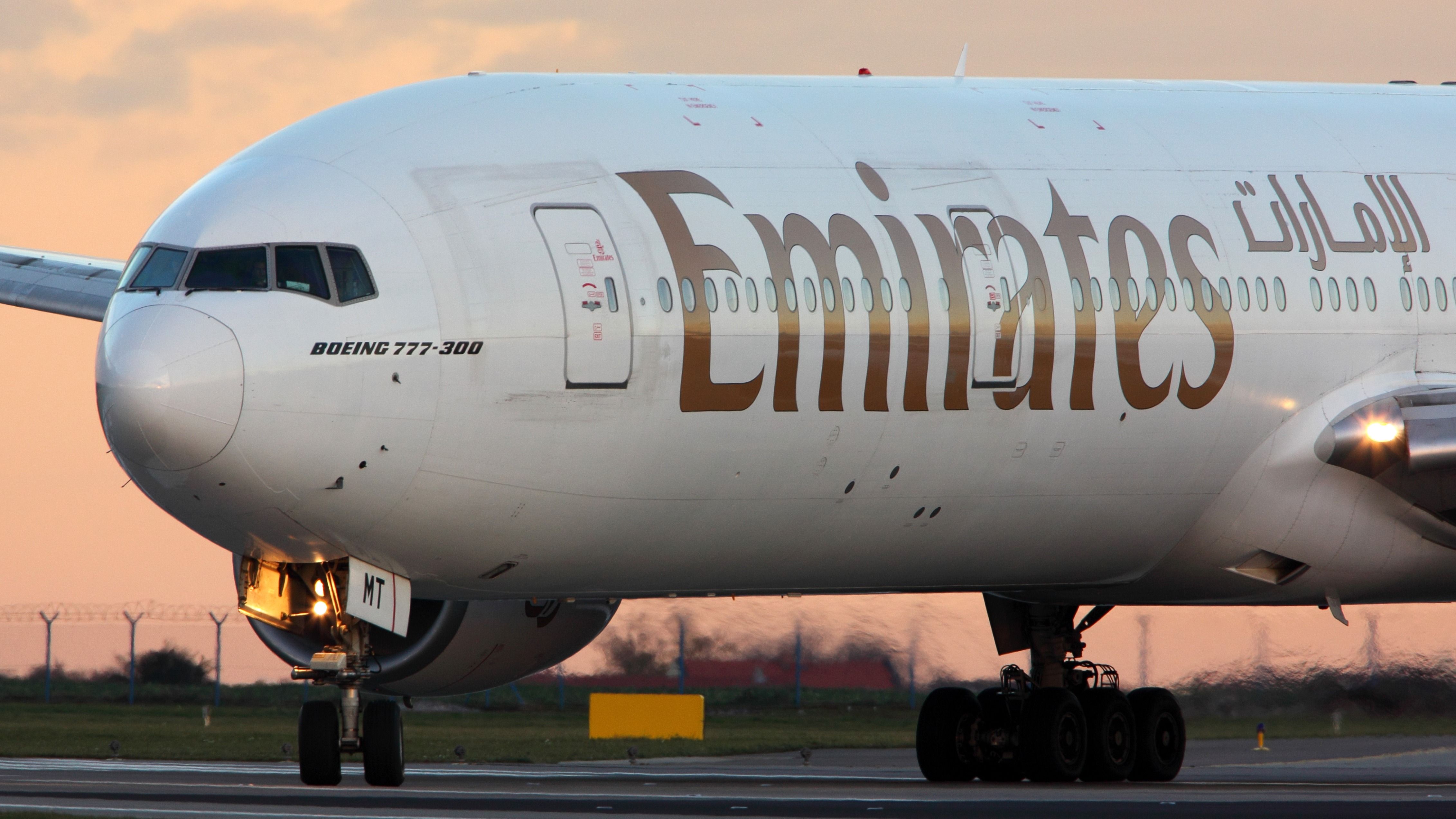 A closeup of an Emirates Boeing 777 on an airport apron.