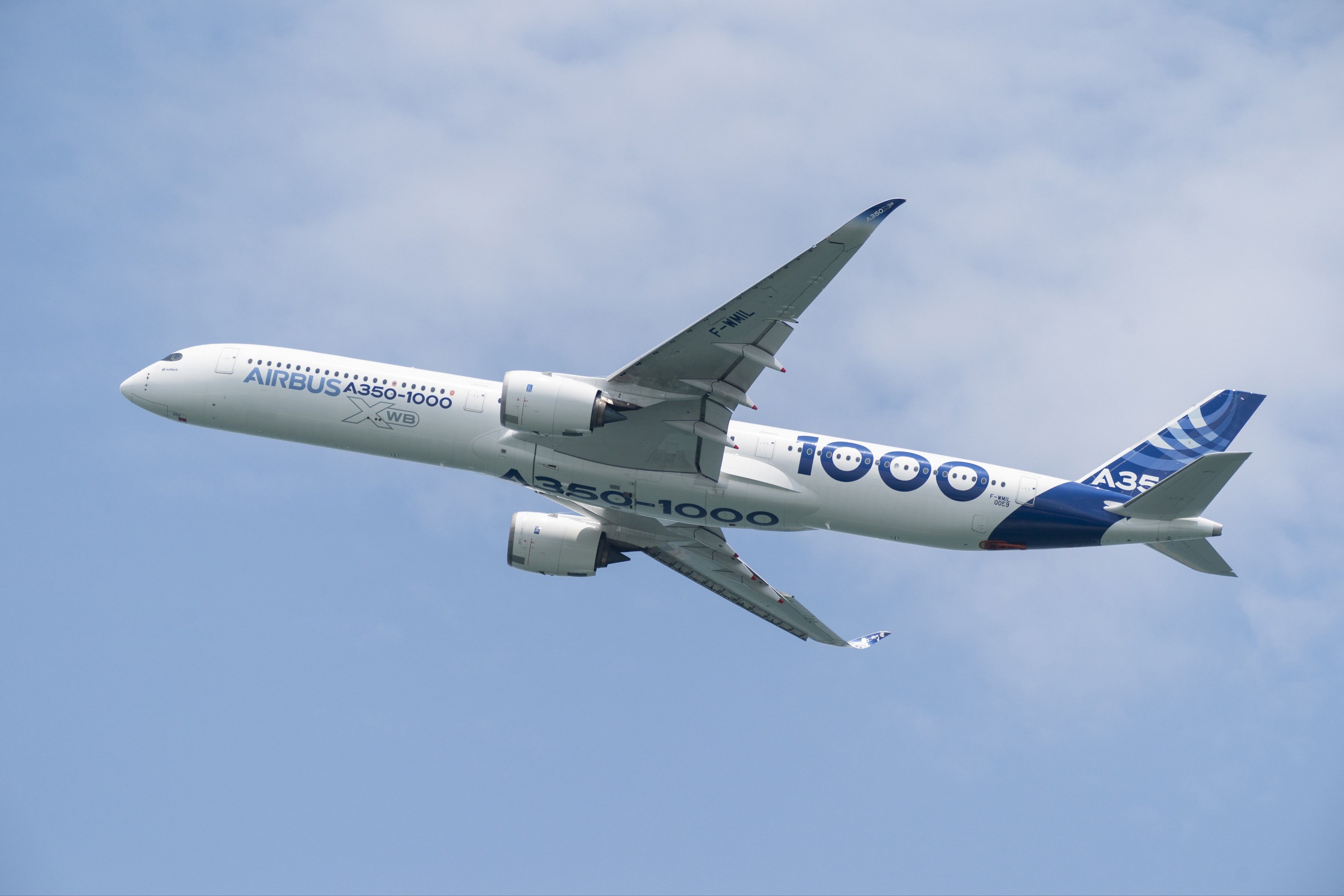 An Airbus A350-1000 in house livery flying in the sky.