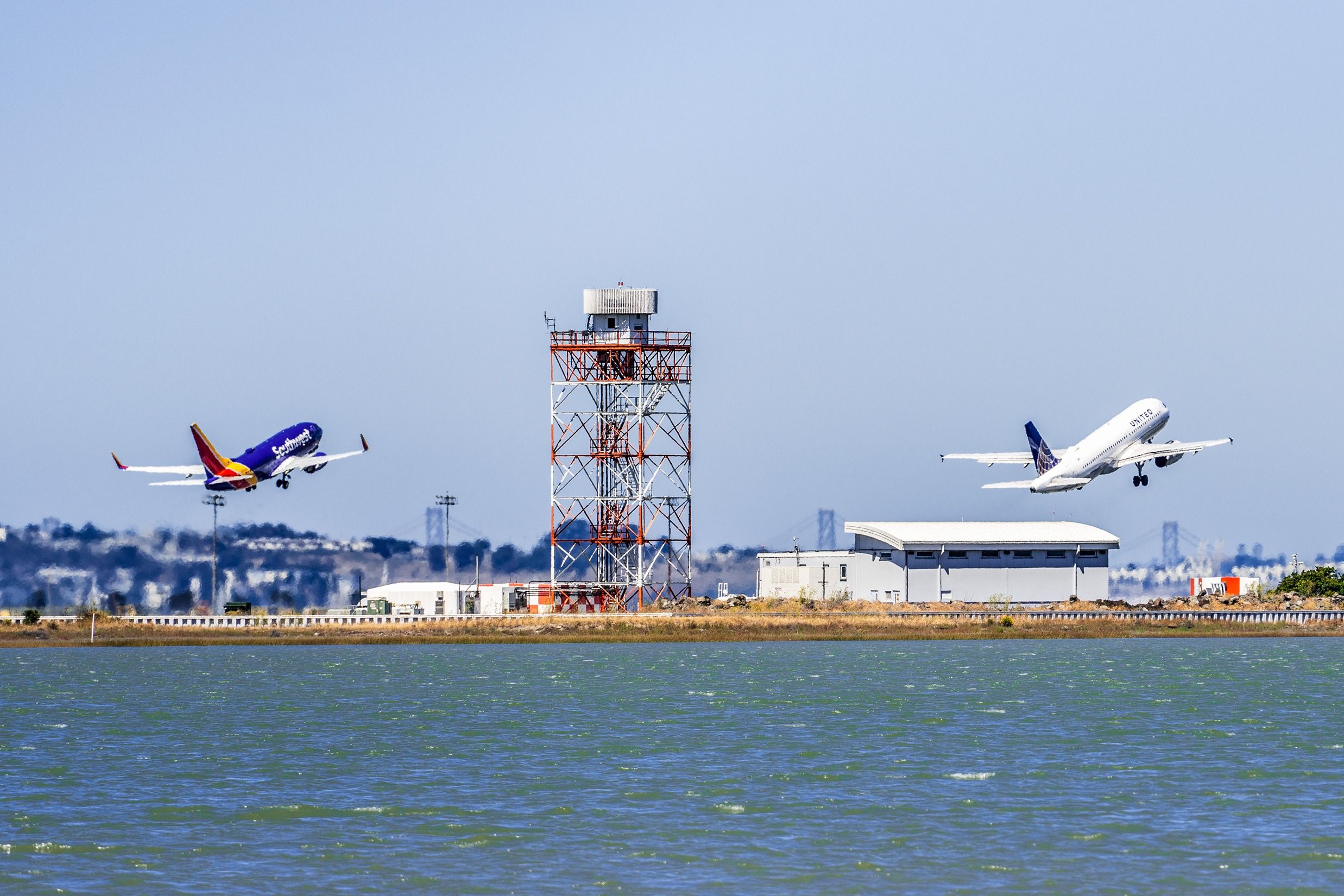 A Southwest Airlines Boeing 737 and United Airlines Airbus A320 performing a parallel takeoff at San Francisco International Airport.