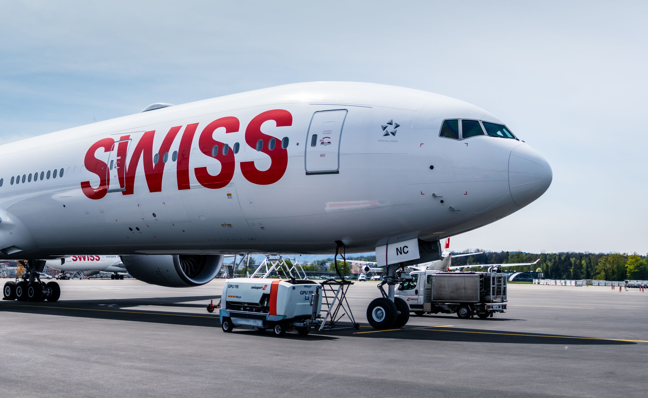 Swiss International Air Lines (SWISS) Boeing 777-300ER parked near a maintenance hangar