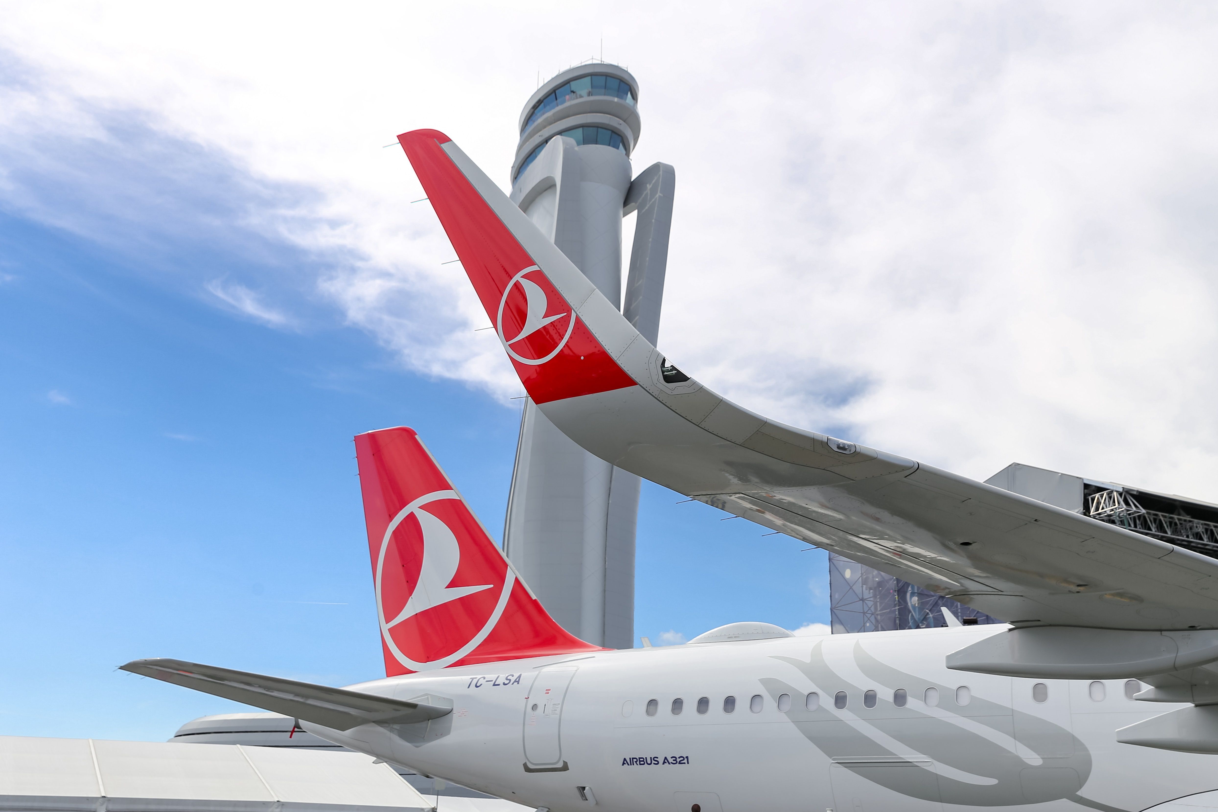 The tail of a Turkish Airlines aircraft on an airport apron.