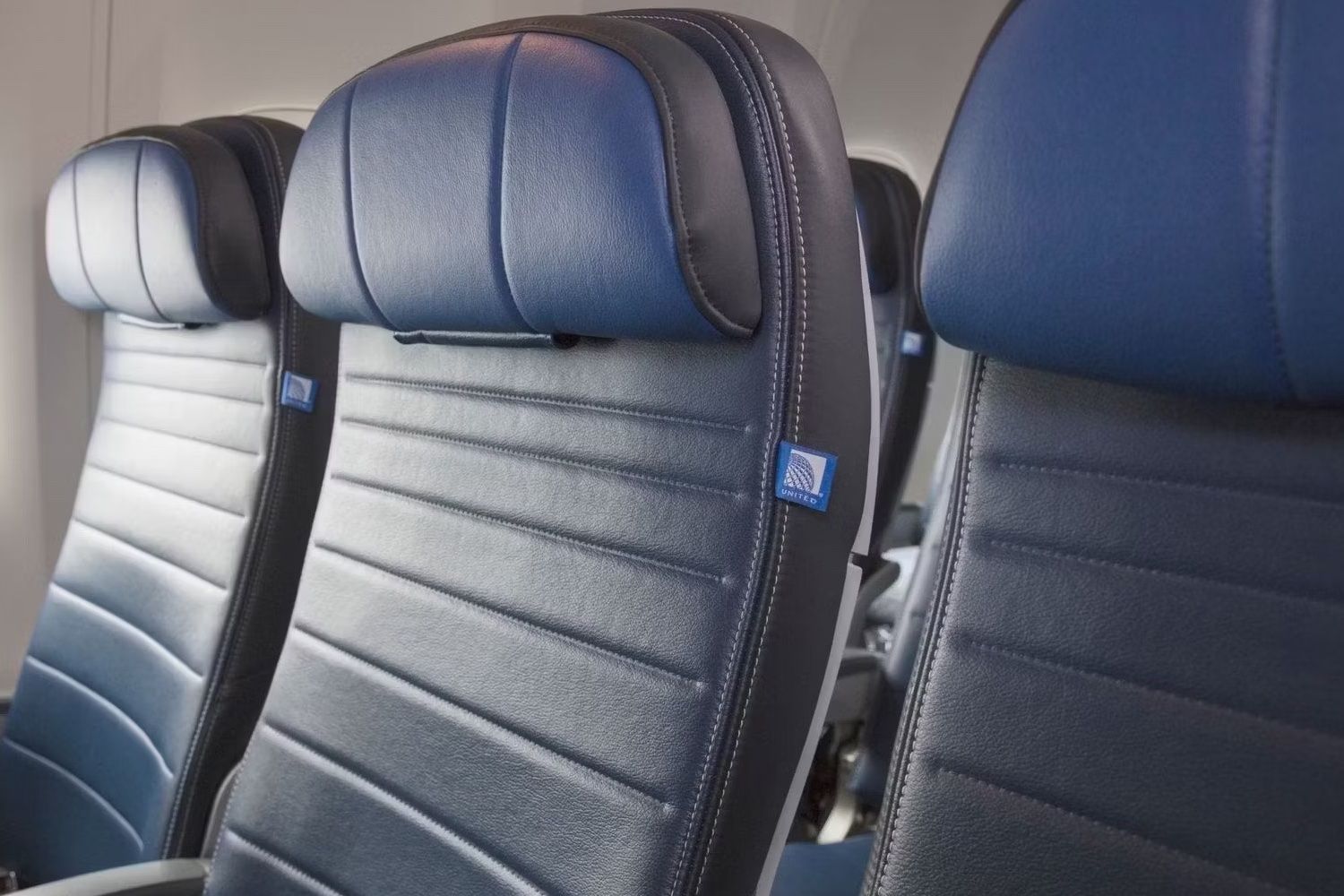 Three United Airlines economy class seats.
