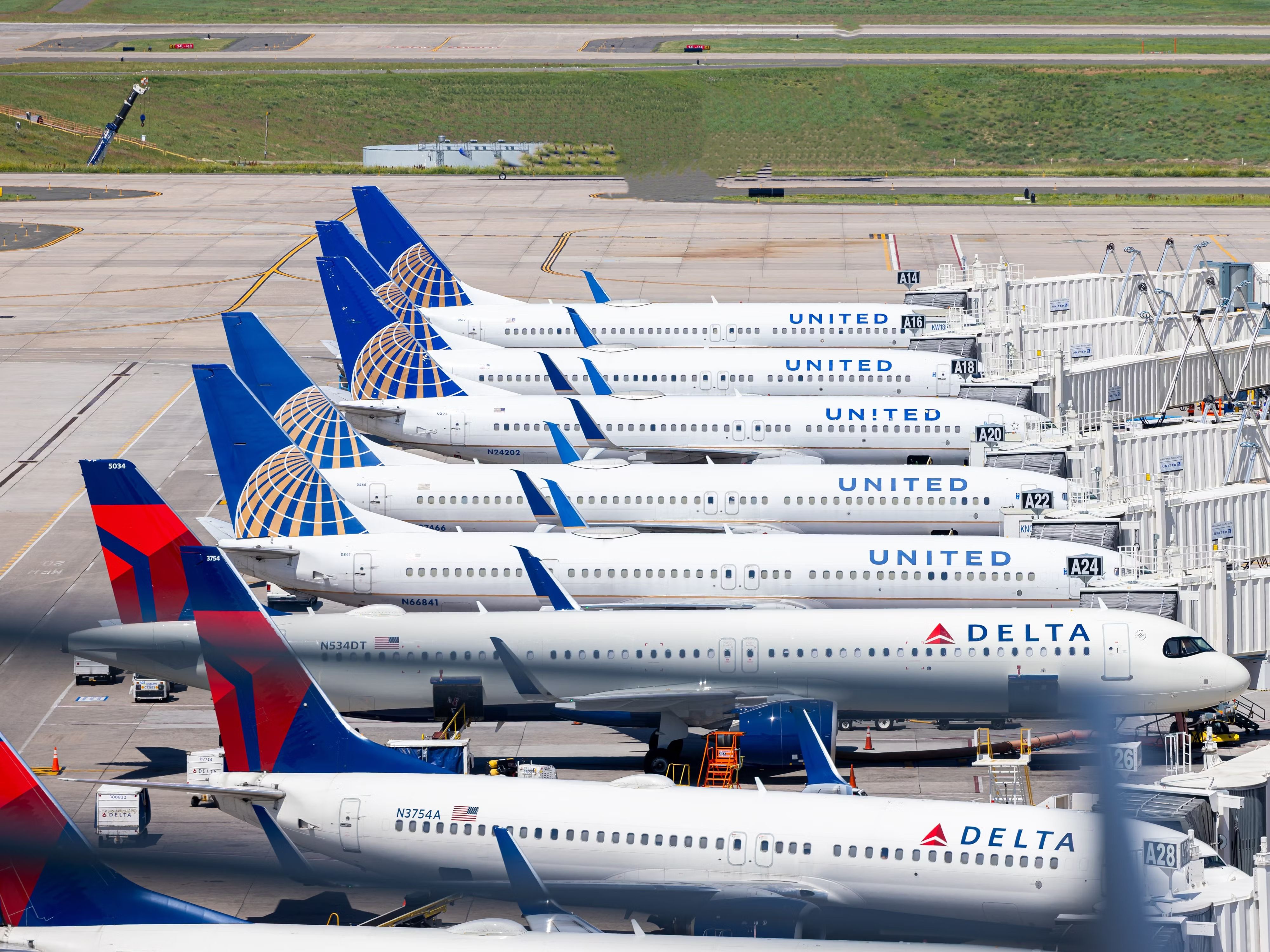 Several United Airlines and Delta Air Lines aircraft parked at gates at Denver International Airport.