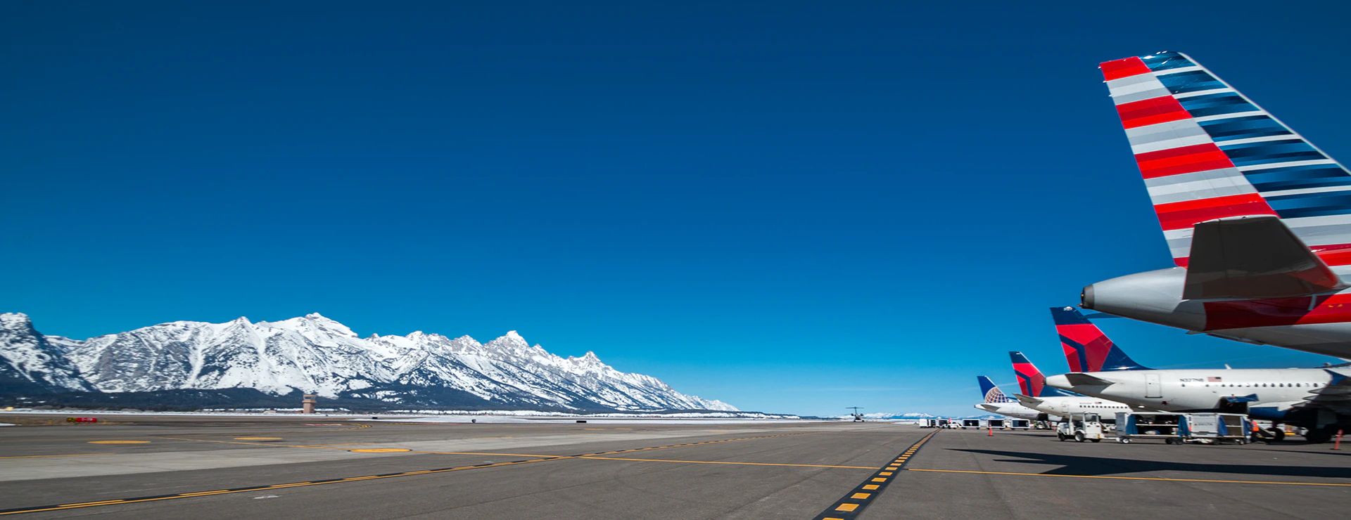 United Airlines, Delta Air Lines, and American Airlines aircraft parked at Jackson Hole Airport.