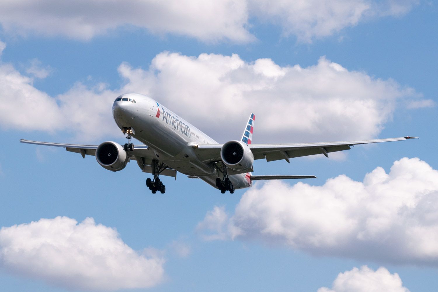 2019-238 - American Airlines Boeing 777 With Gear and Flaps Down In Front of Puffy Clouds