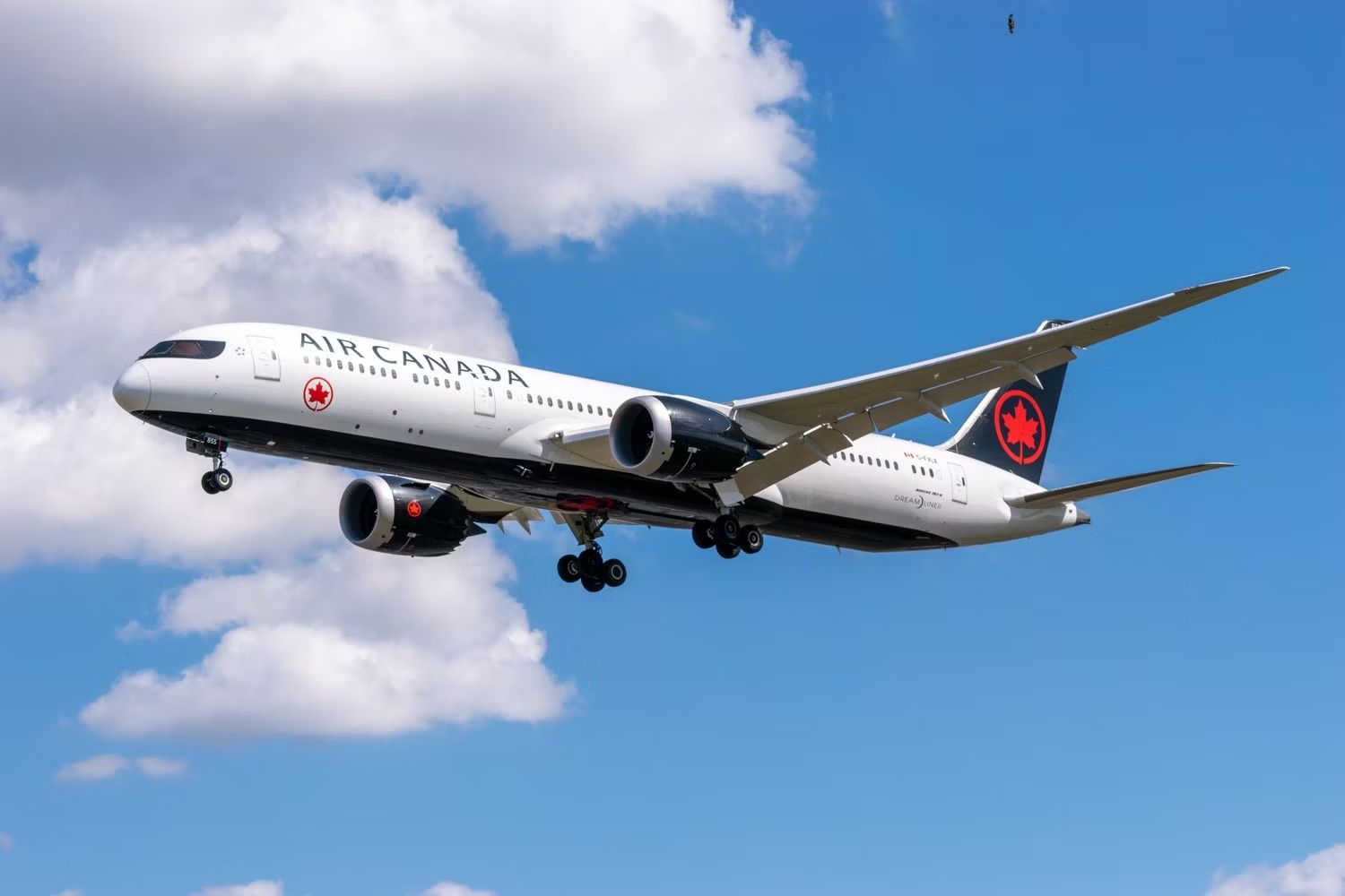 An Air Canada Boeing 787 flying in the sky.