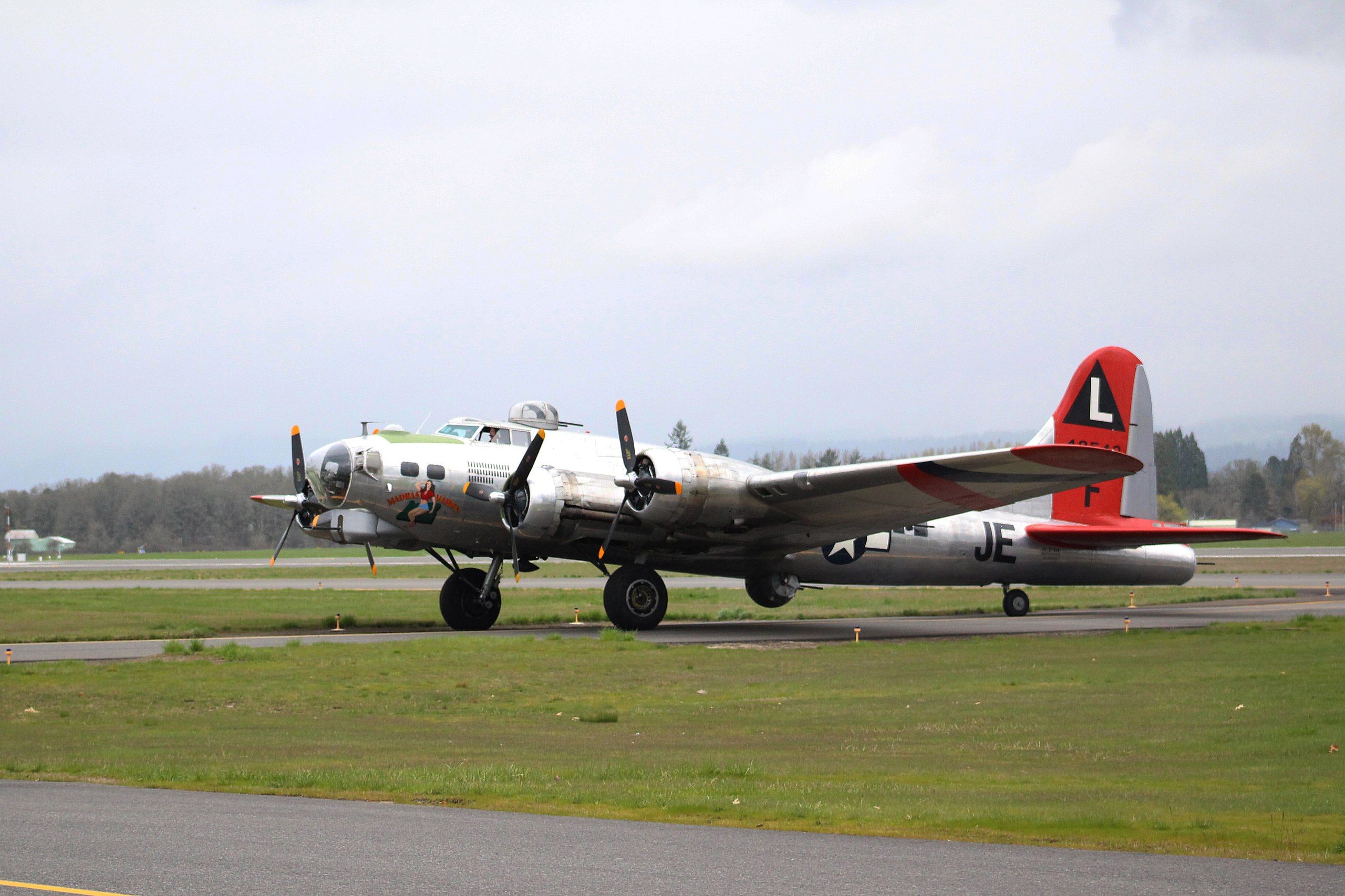 The B-17 named Madras Maiden parked at an airfield.