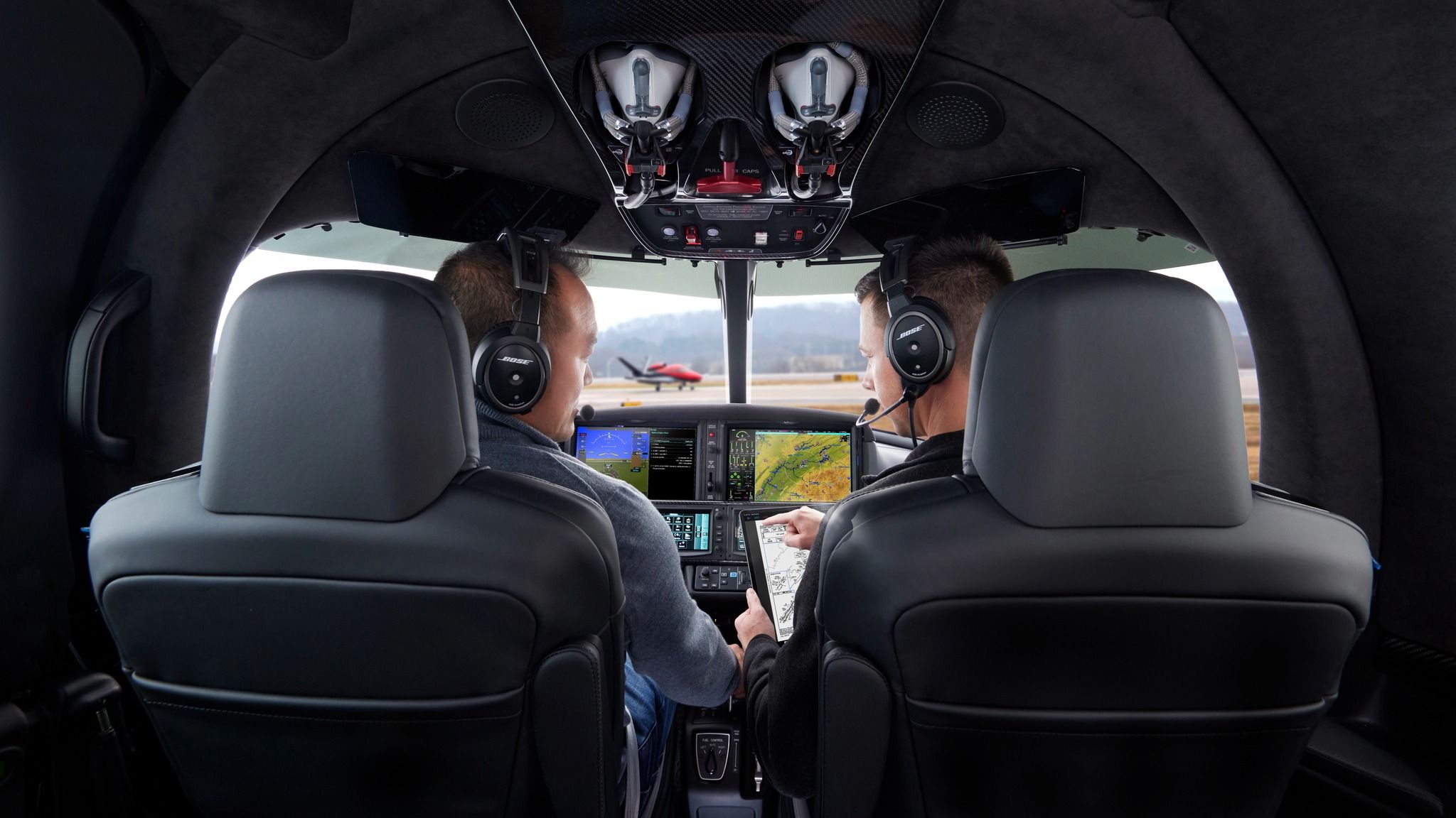 Two pilots sitting in the cockpit of a Cirrus Vision jet.