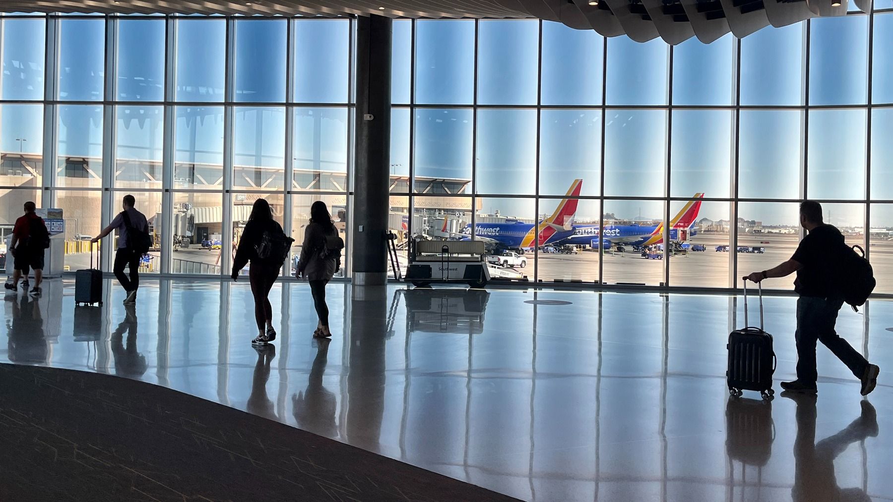 Travelers walking through Southwest Airlines concourse at Phoenix Sky Harbor International Airport.