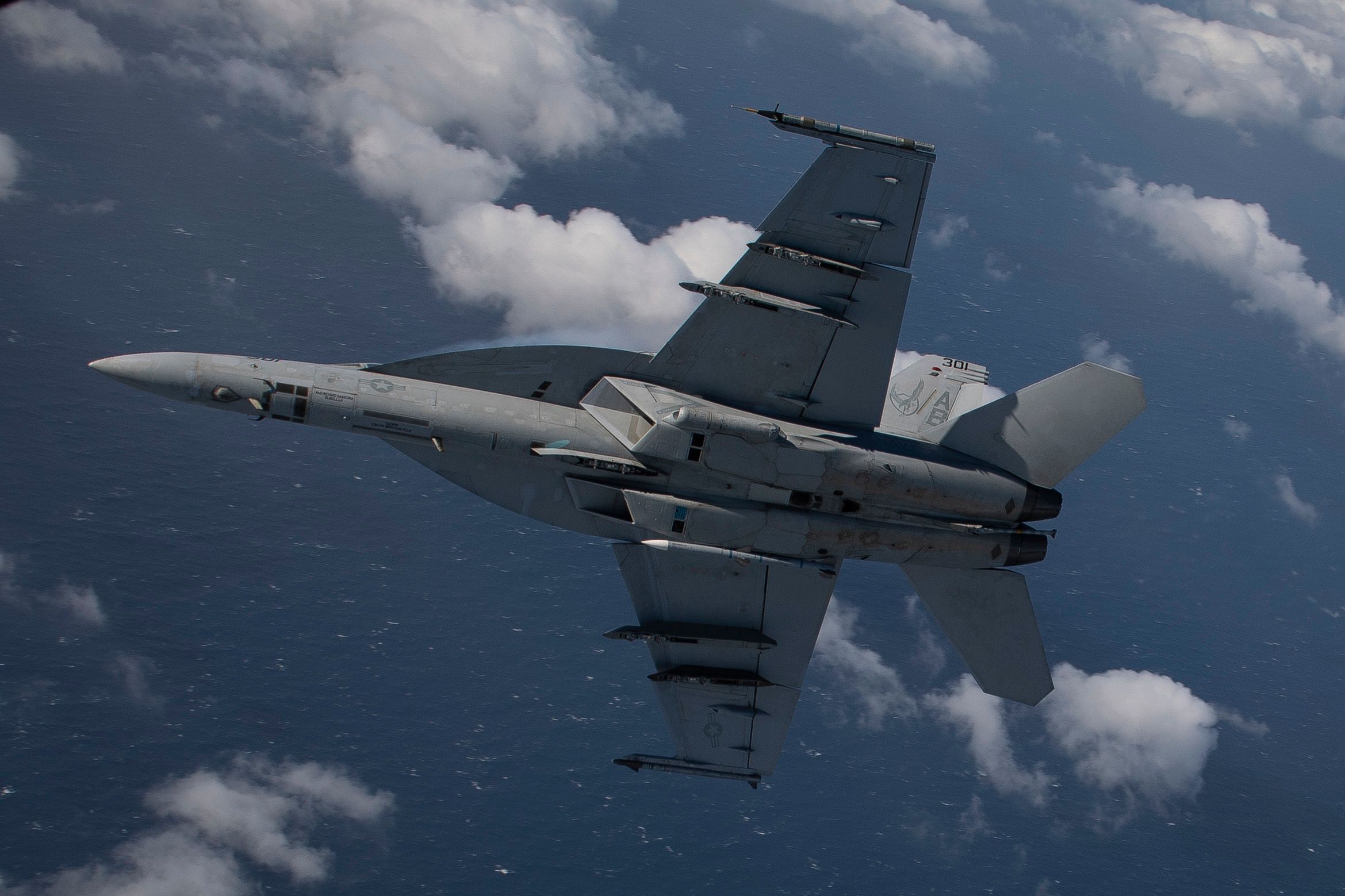 A Boeing F/A-18E Super Hornet turns sharply in the sky.