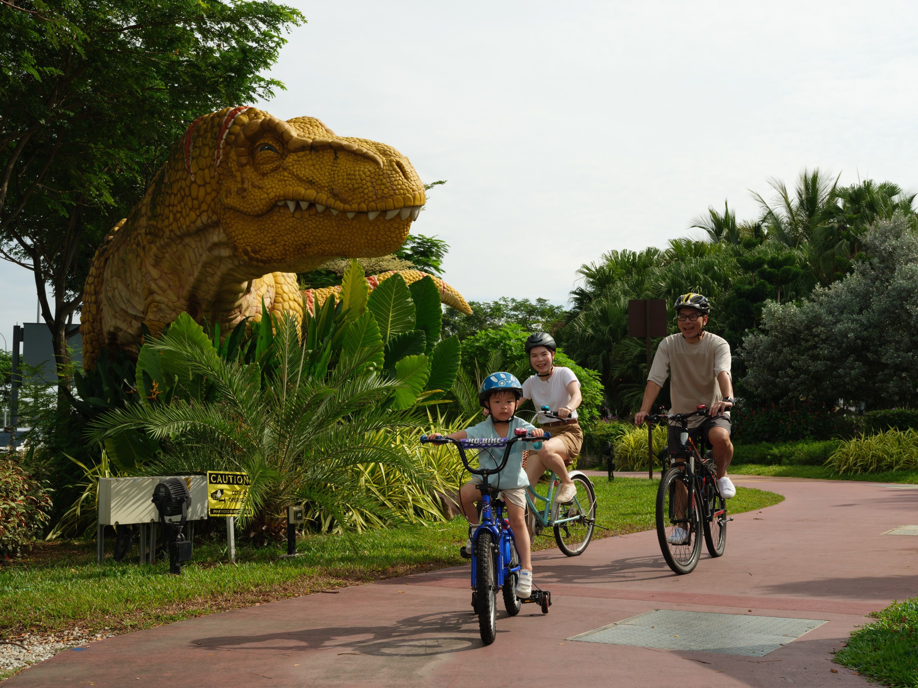 A small family riding bicycles at a park.