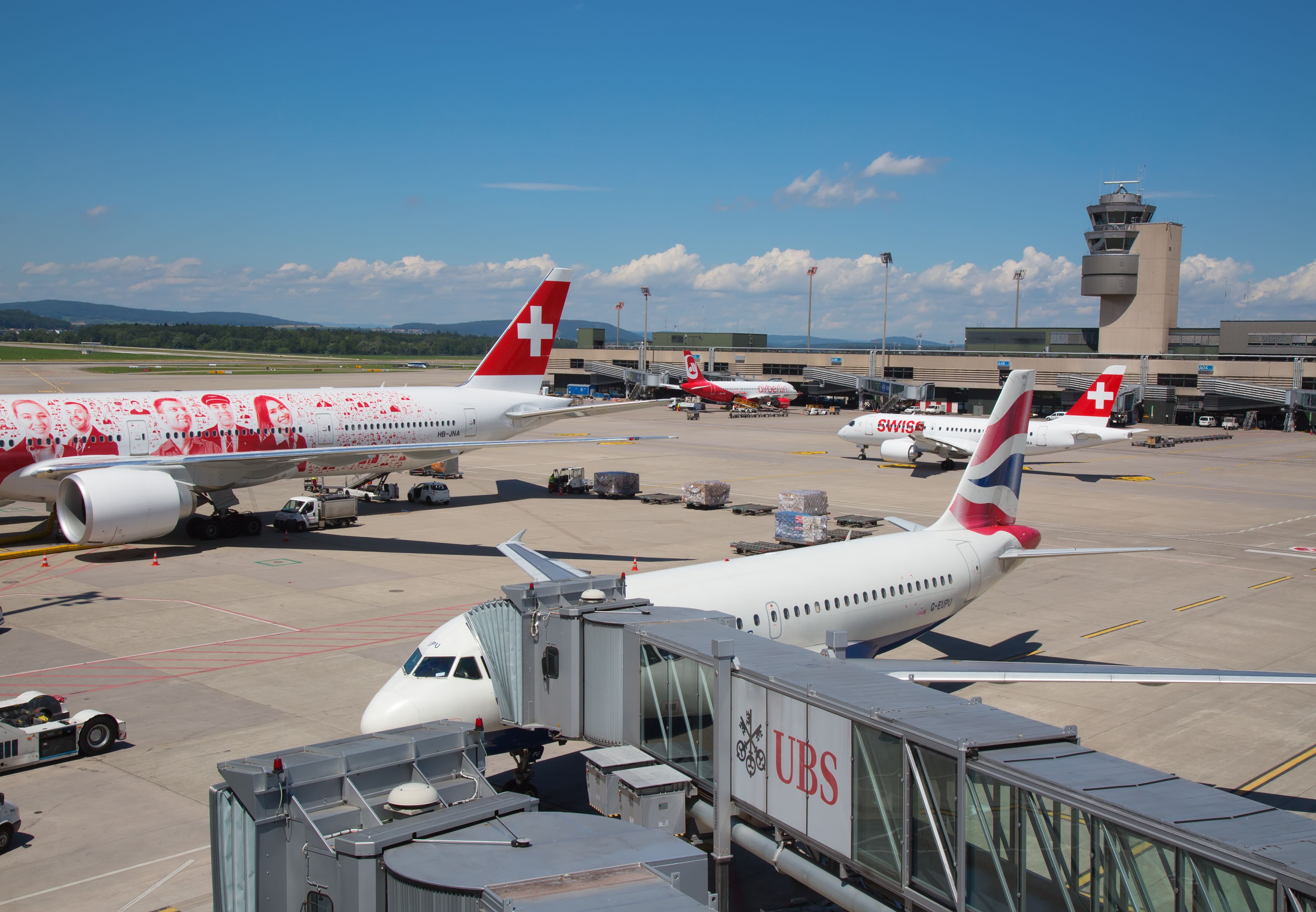 A view of Zurich Airport with SWISS and British Airways aircraft parked at gates.