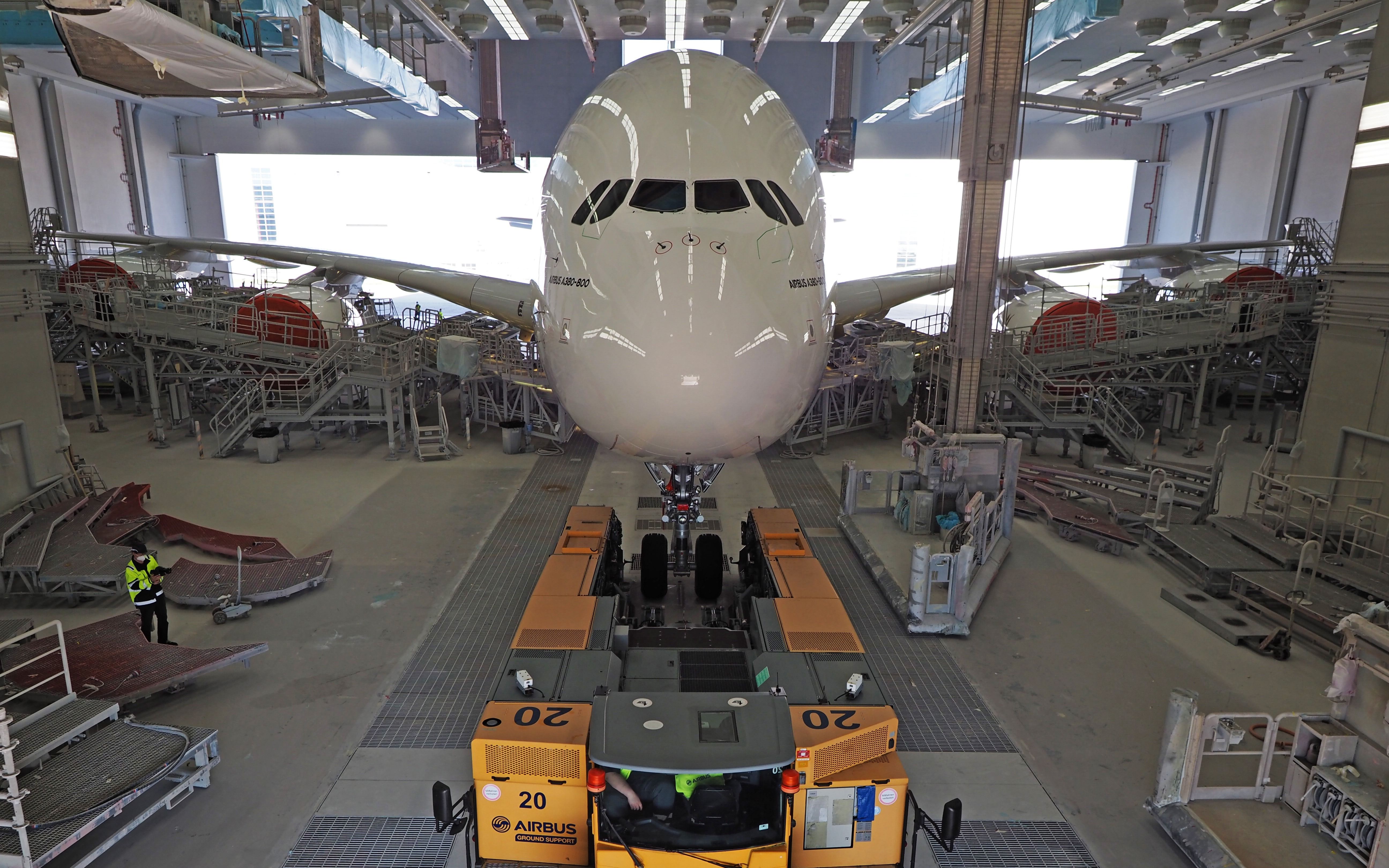 A White Airbus A380 Being Moved Into A Painting Facility.