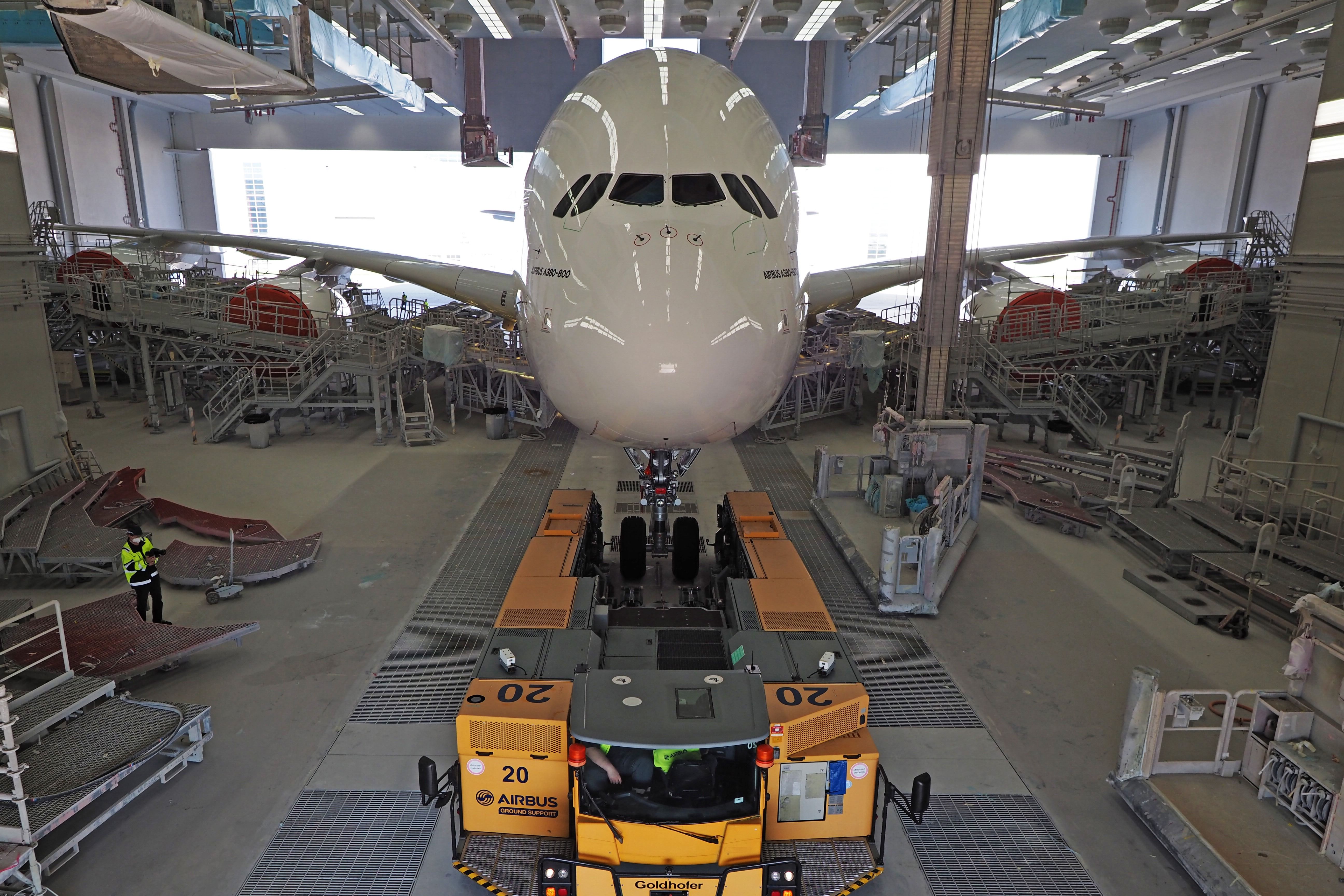 A White Airbus A380 Being Moved Into A Painting Facility.