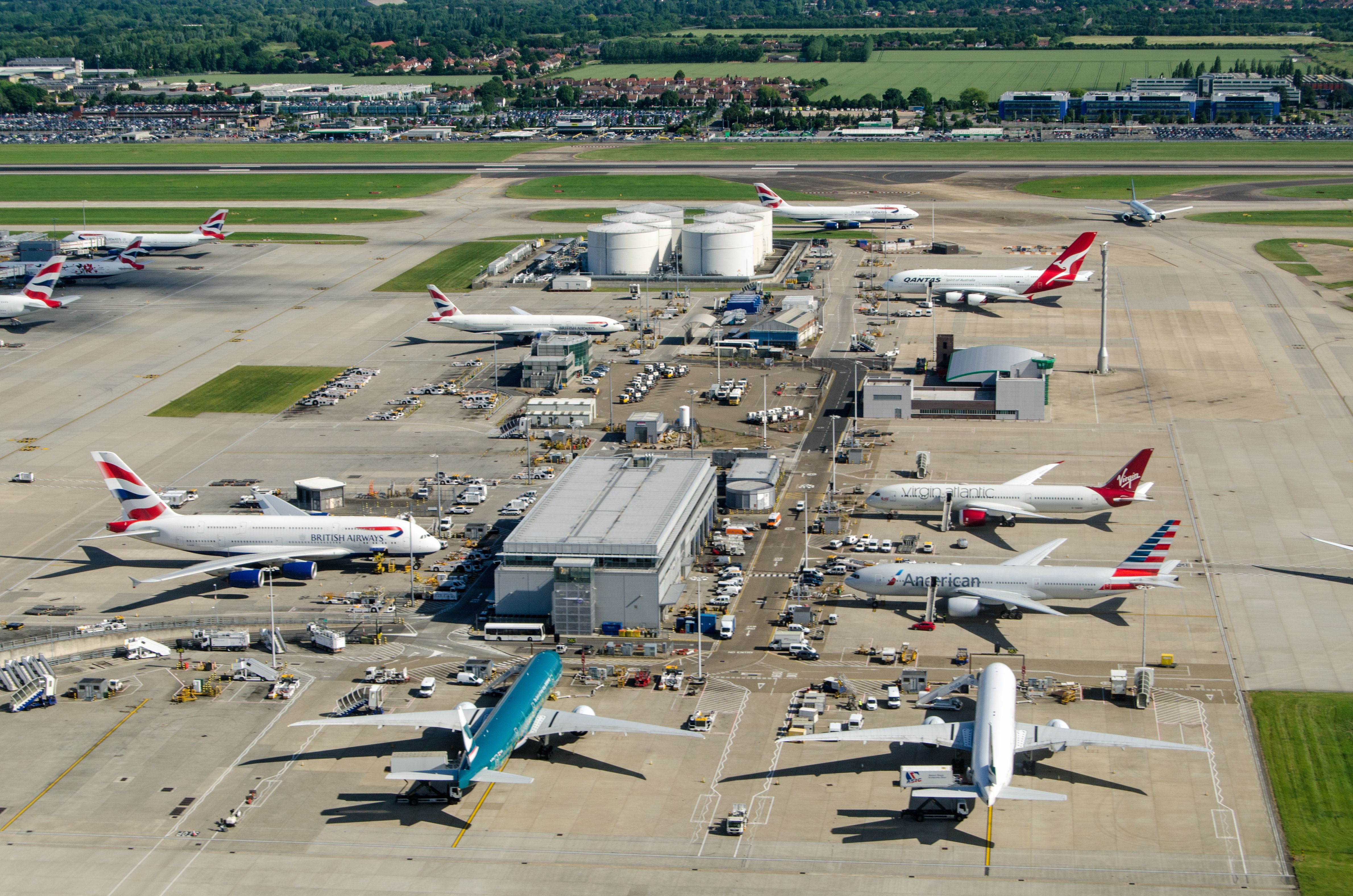 Several aircraft from many different carriers on the apron at London Heathrow airport.