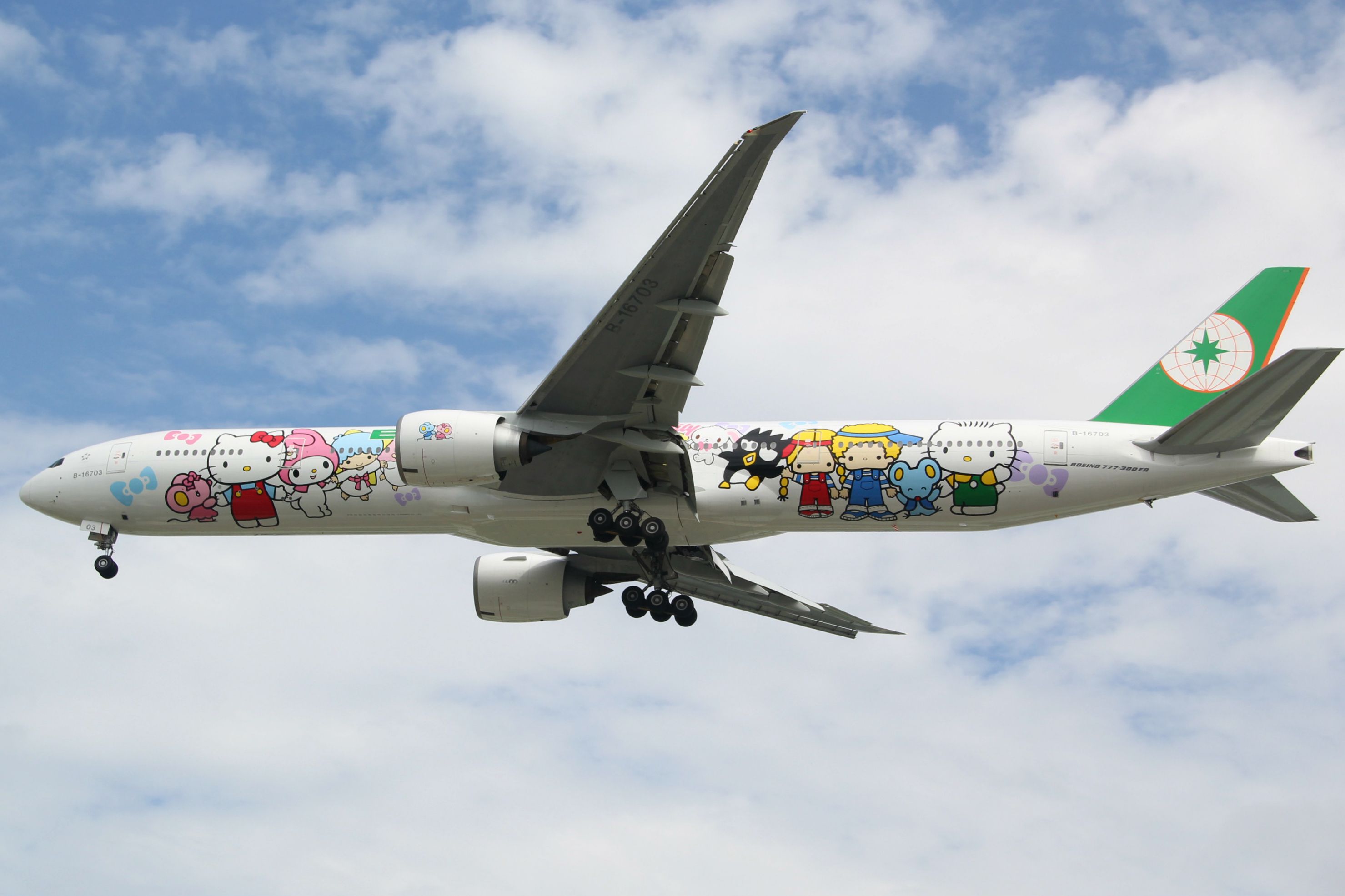 長榮航空波音 777 上繪有 Hello Kitty 和其他三麗鷗角色，塗有鮮豔的色彩，在天空中飛行。