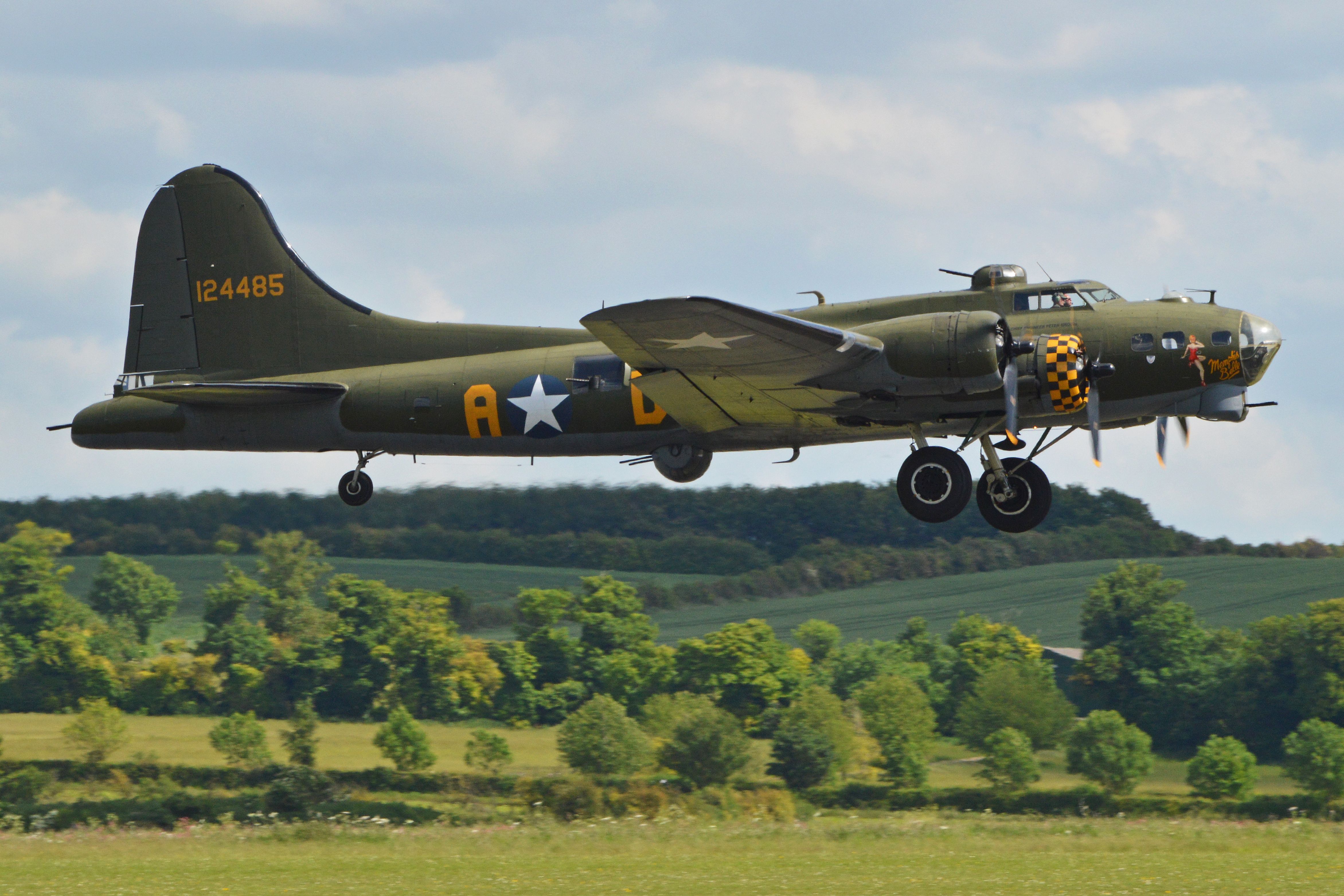 A B-17 flying fortress flying close to the ground.