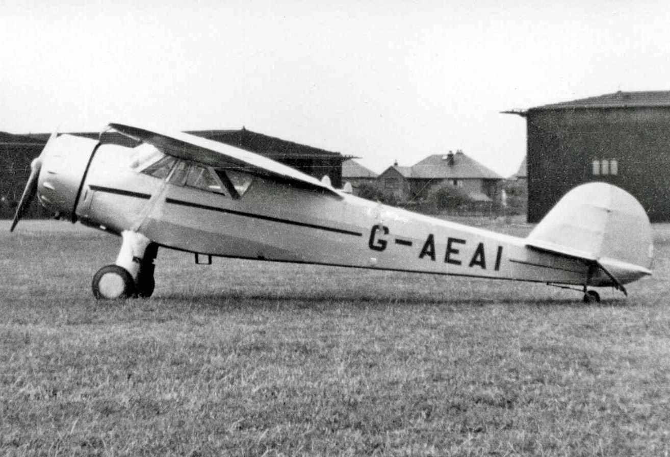 A Cessna C-34 parked in a grass field.