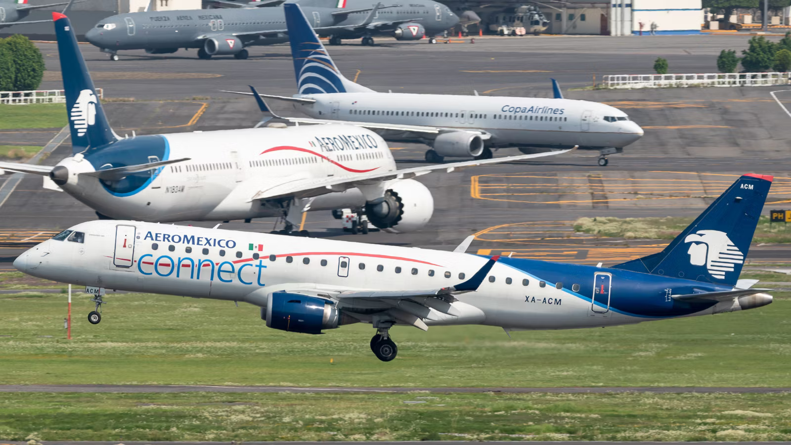 An Aeroméxico Connect Embraer ERJ-190-100LR flying in front of Aeroméxico and CopaAirlines aircraft.