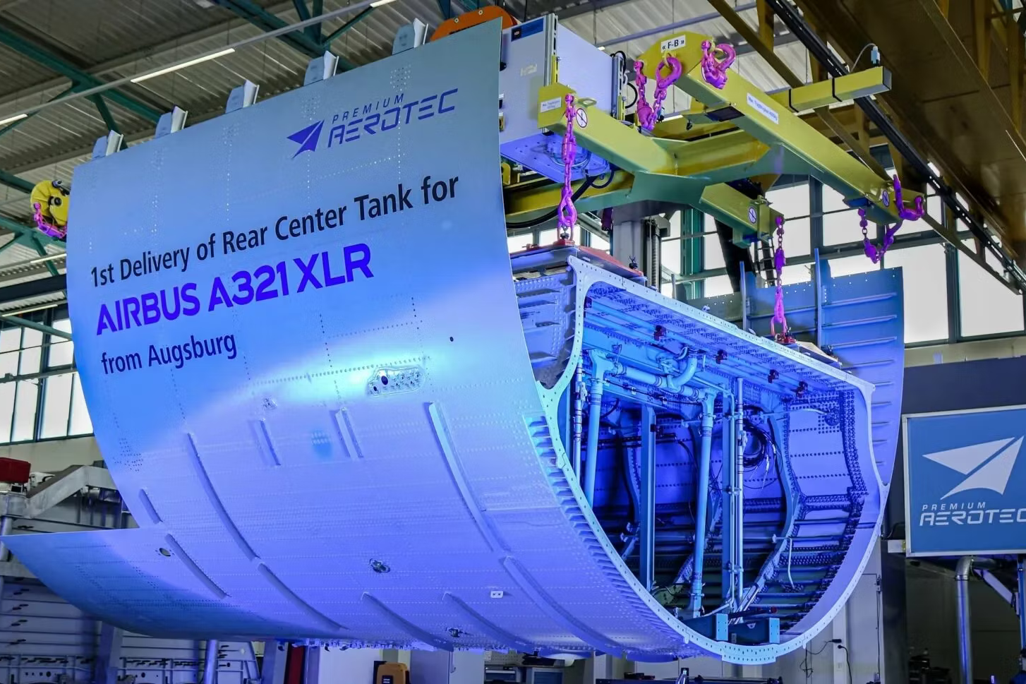 The rear center fuel tank of an Airbus A321XLR being lifted by a machine.