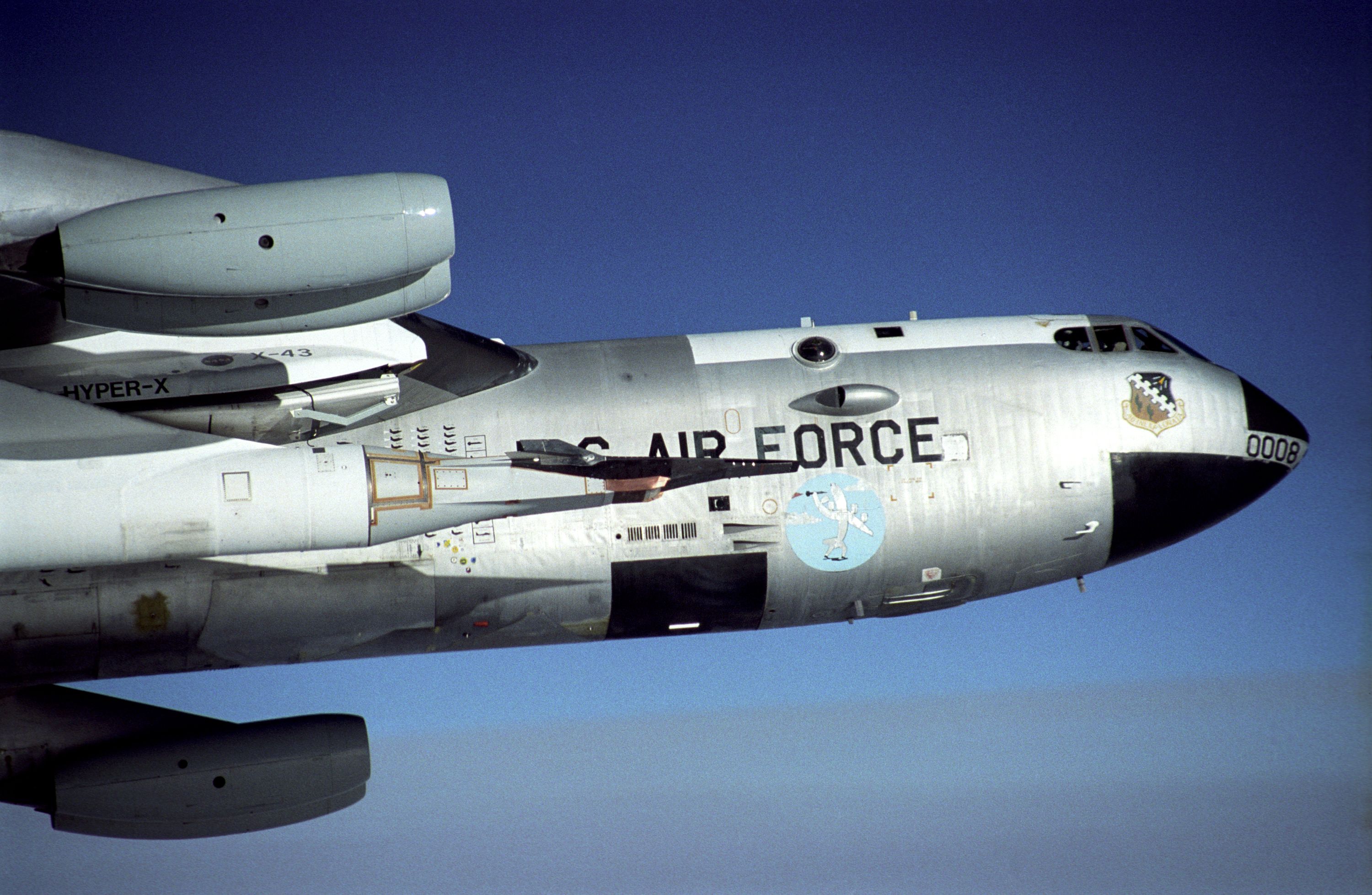  black X-43A rides on the front of a modified Pegasus booster rocket hung from the special pylon under the wing of NASA's B-52B mother ship