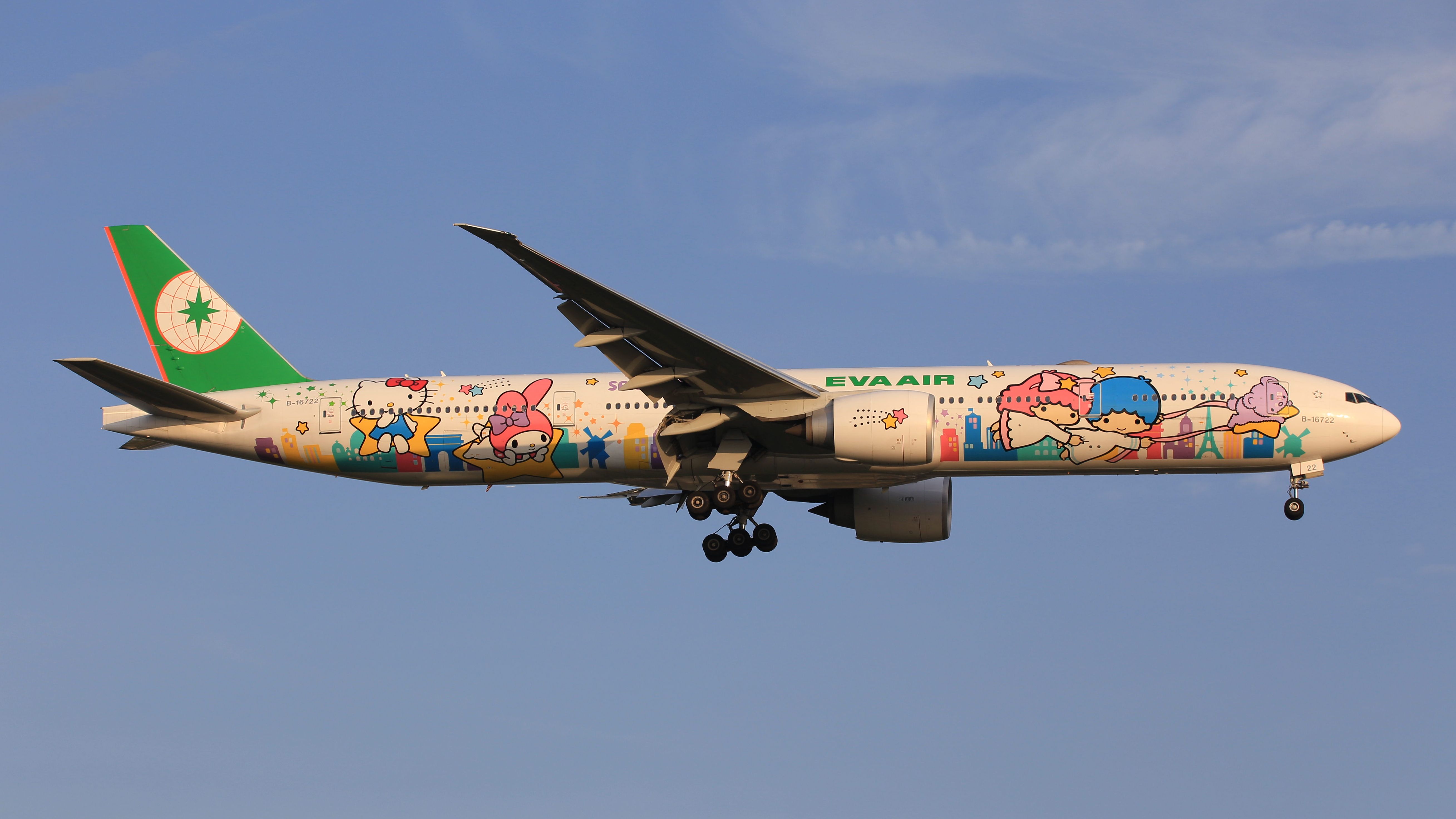 An EVA Air Boeing 777-300ER with a Hello Kitty Sanrio livery flying in the sky.