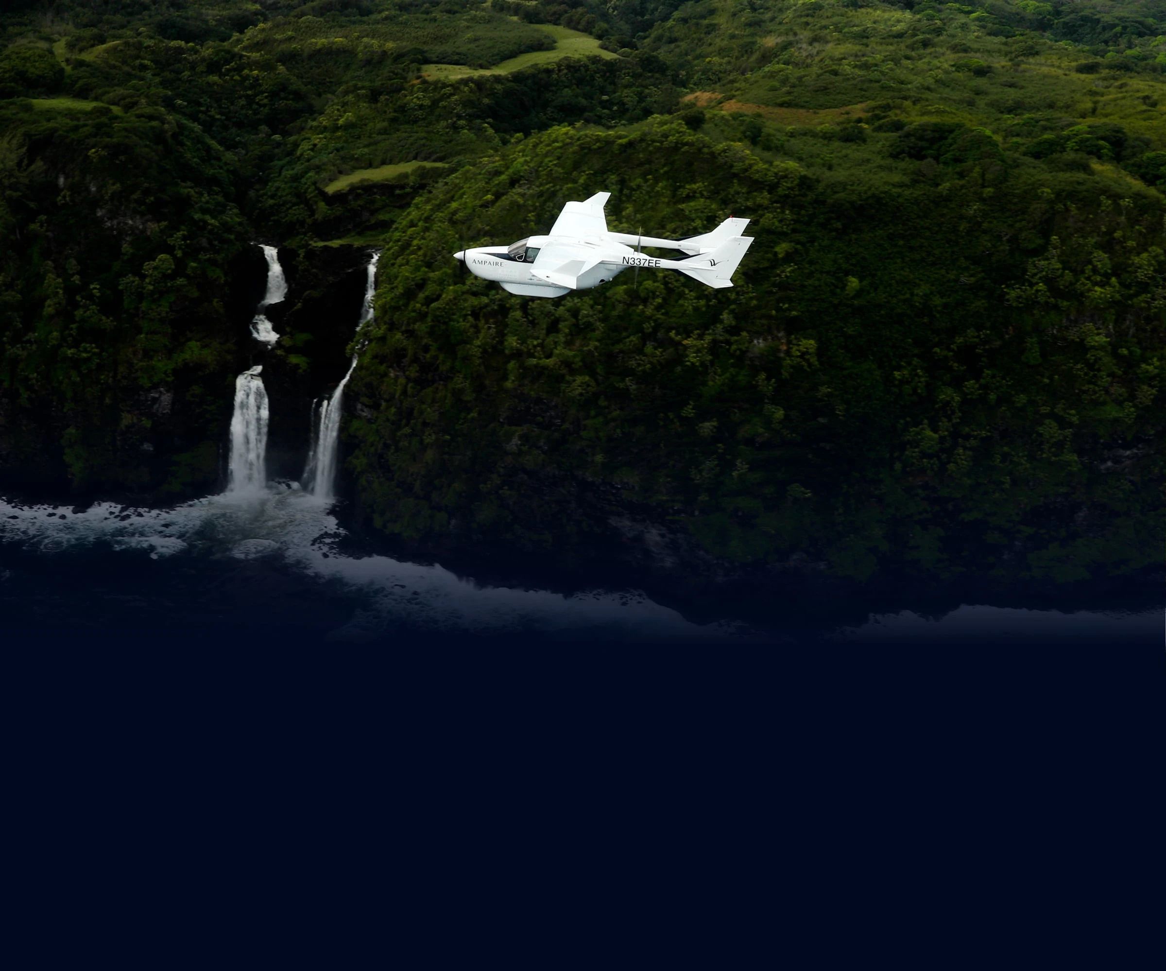 White aircraft flying near vegetation-covered cliff with a waterfall on the ocean's edge