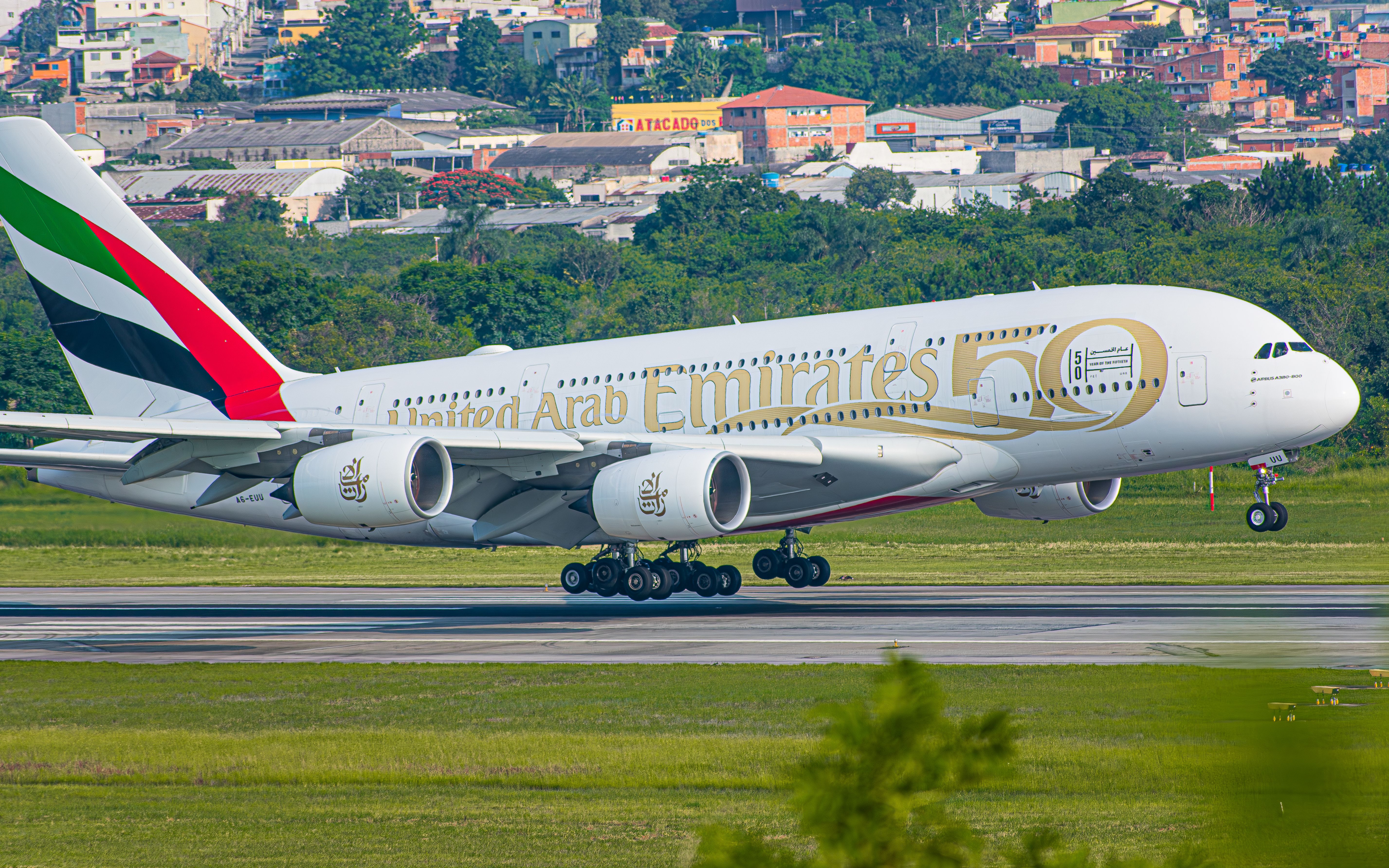 An Emirates Airbus A380 about to land on a runway.