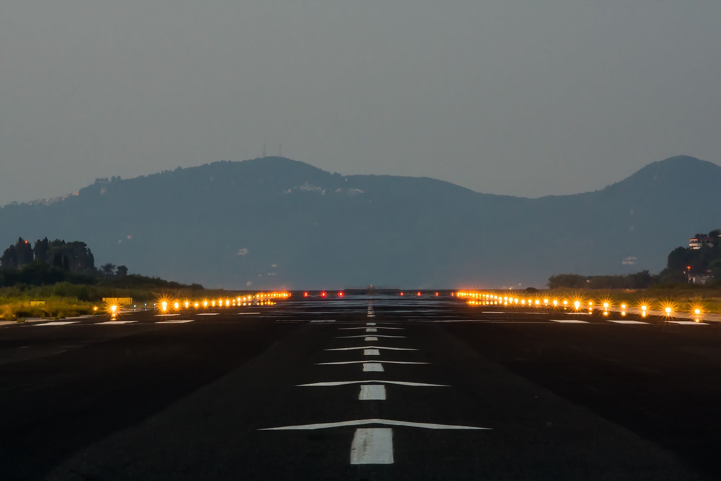 A ground-level view of a short runway with mountains in the background.