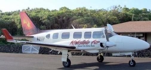 White Piper Navajo Chieftain aircraft with Mokulele Air painted on the side in red parked at Hana Airport