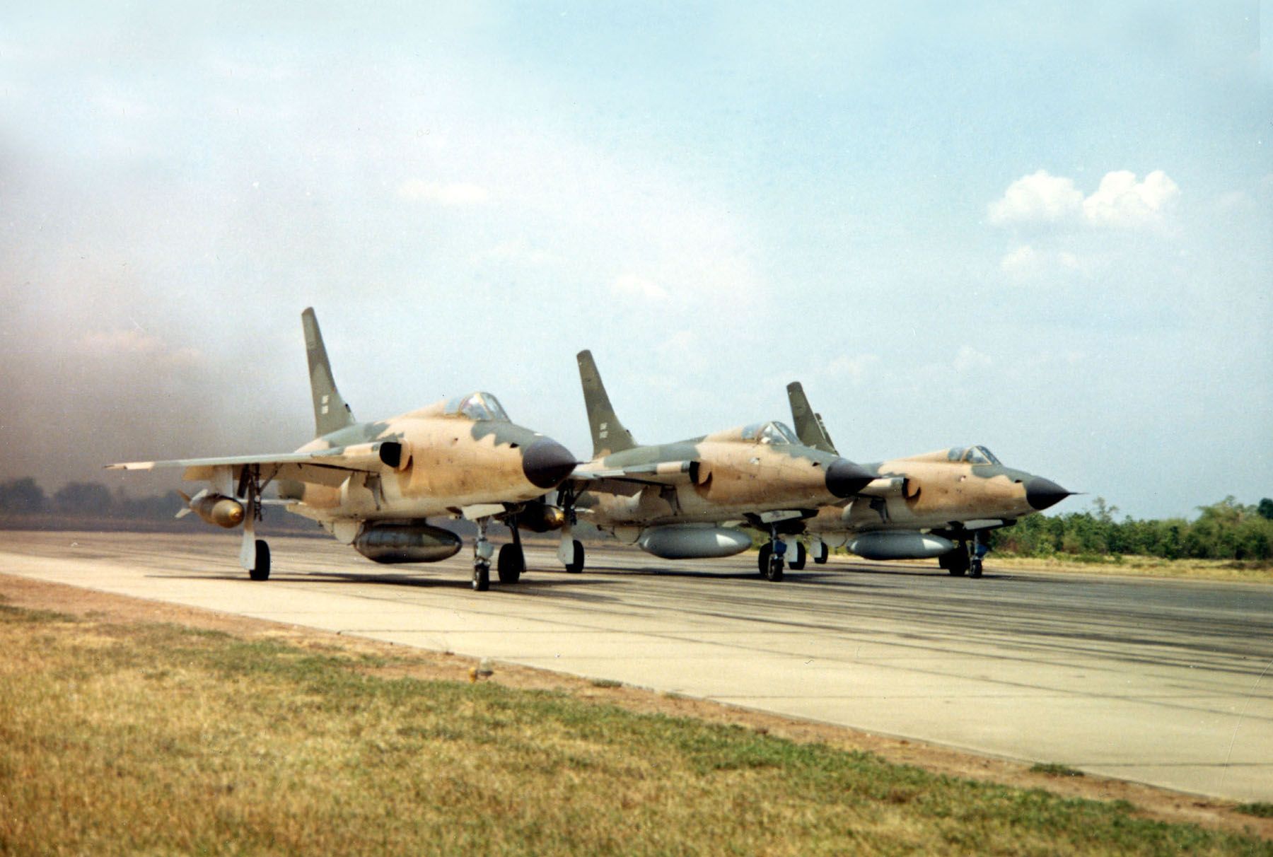 Three F-105 Thunderchiefs on an airfield in Vietnam.