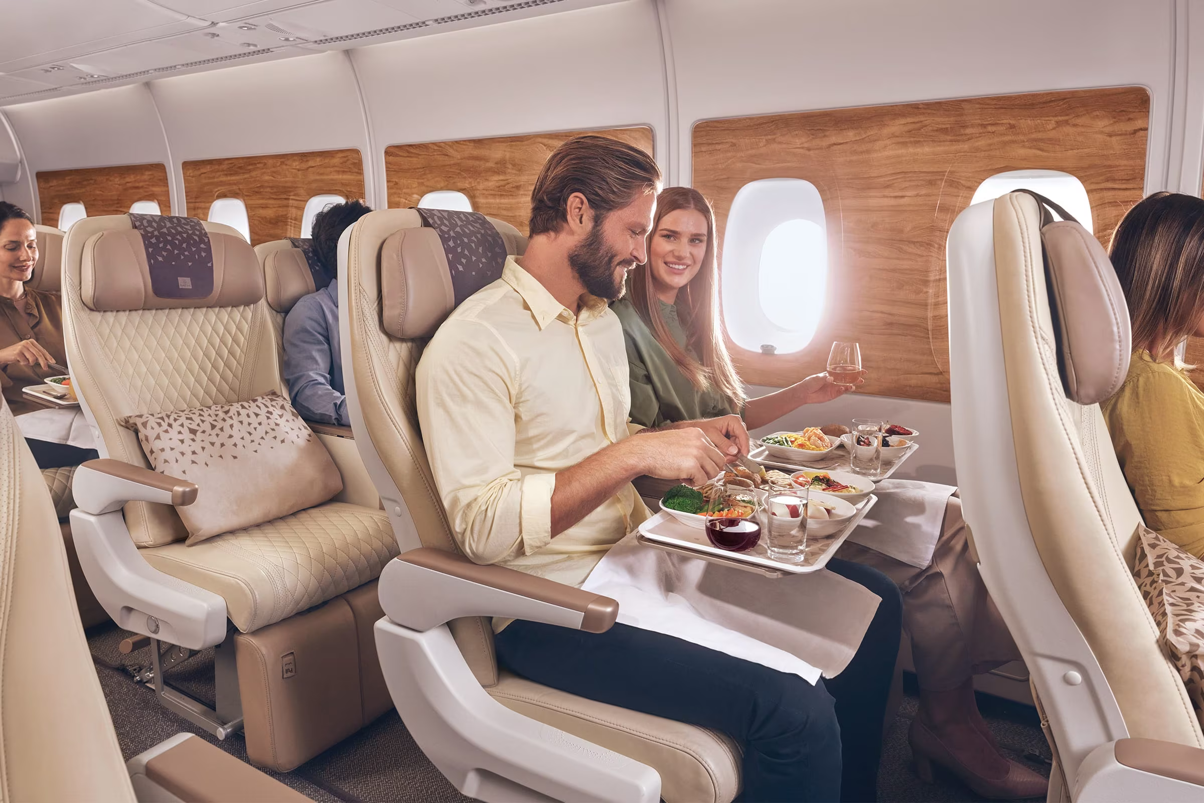 Several passengers eating dinner in the Emirates Premium Economy Cabin.