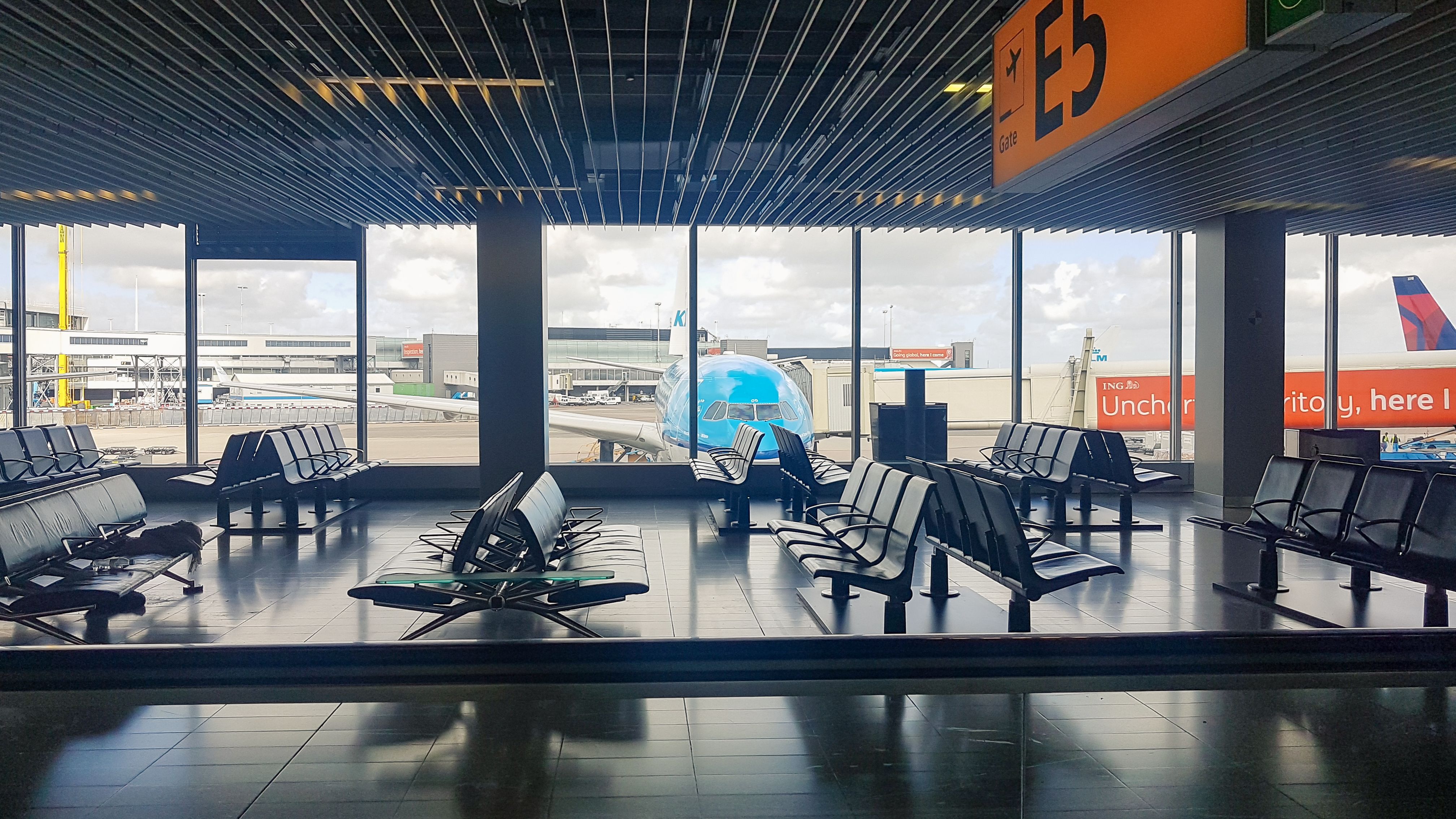 A departure lounge in Amsterdam, with a KLM aircraft parked at the gate.