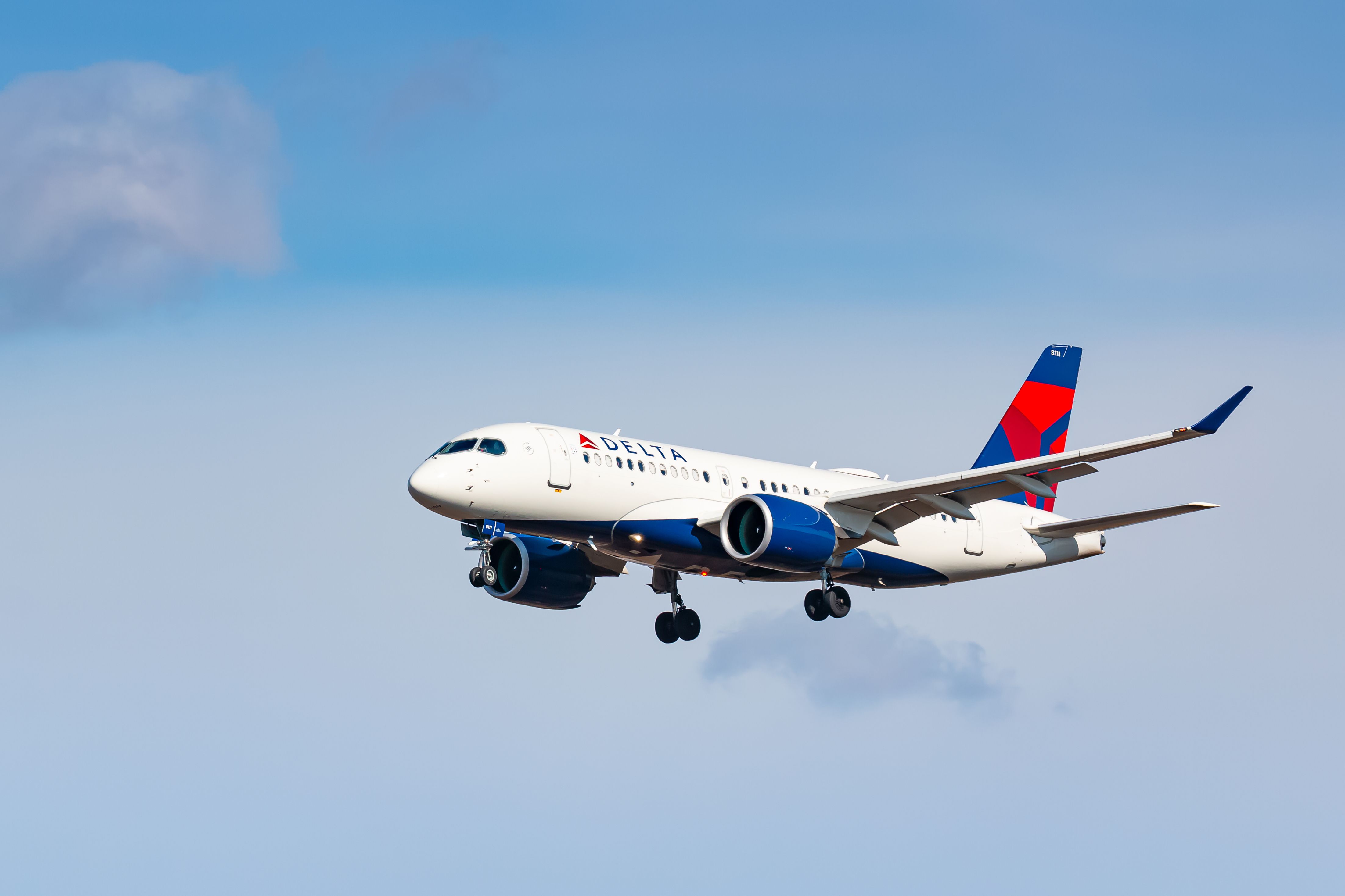 A Delta Air Lines A220-300 flying in the sky.