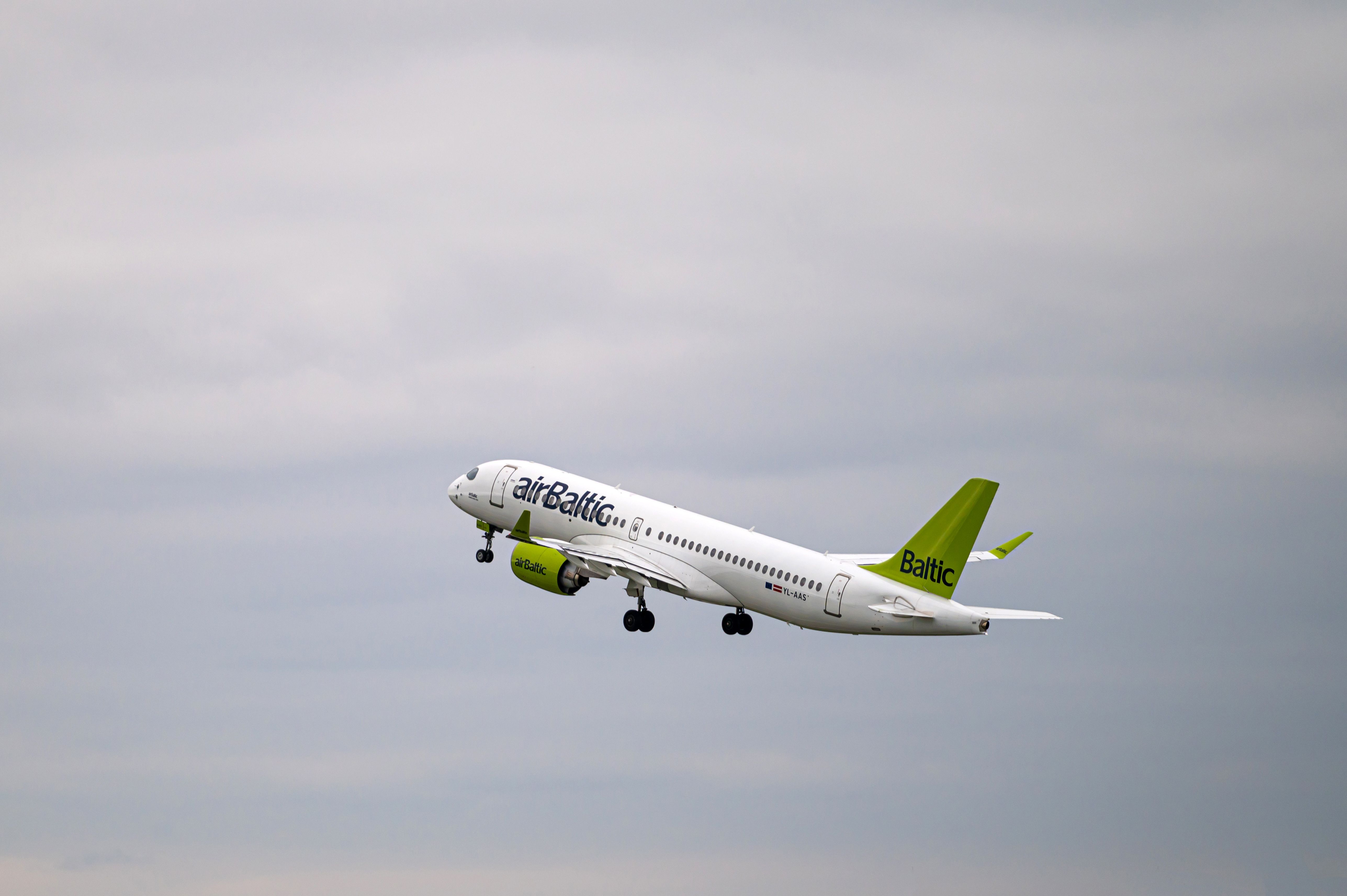AirBaltic Airbus A220-300 YL-AAS takes off from RIX International Airport on cloudy autumn day.