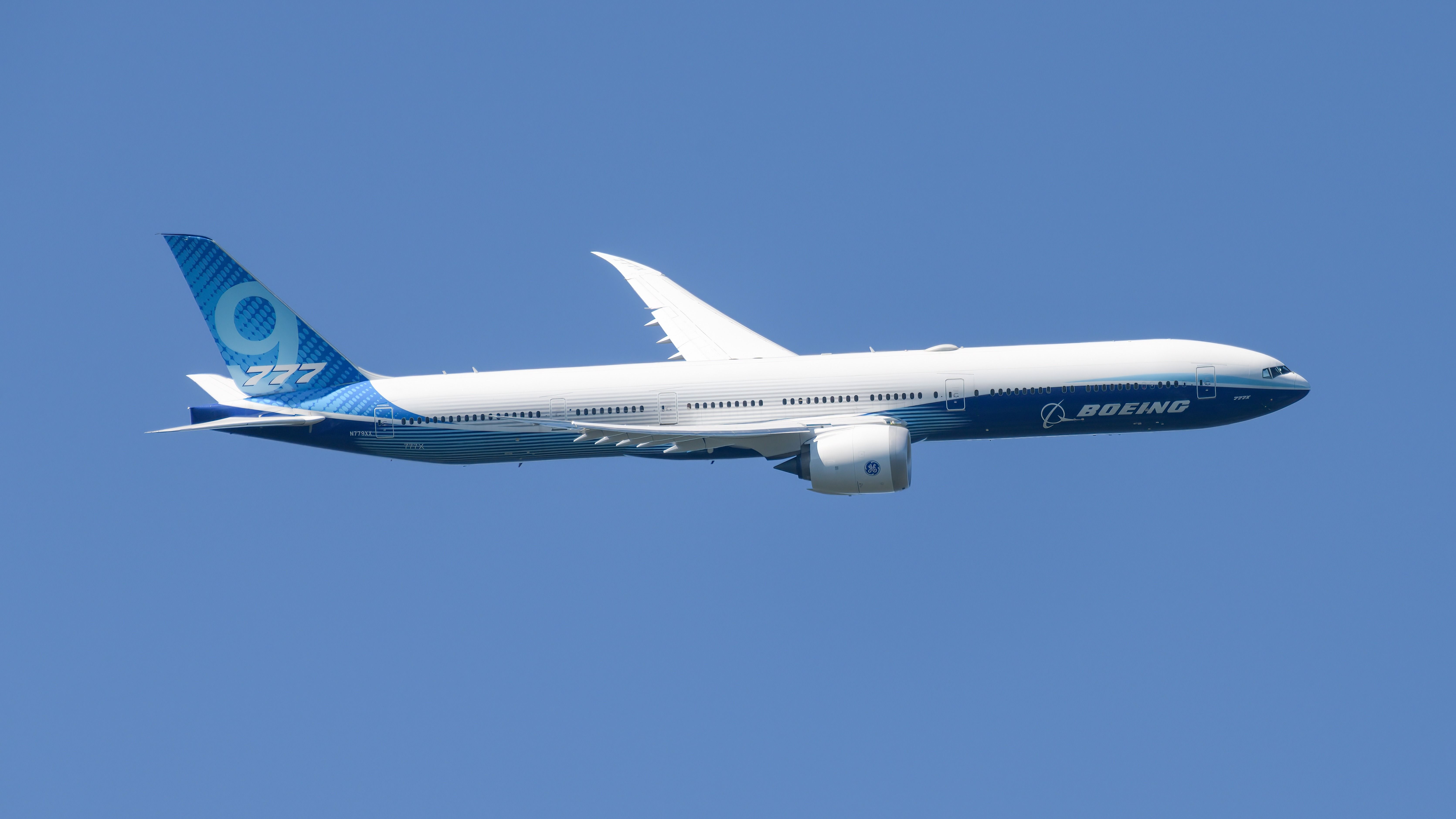 A Boeing 777X flying in the sky.