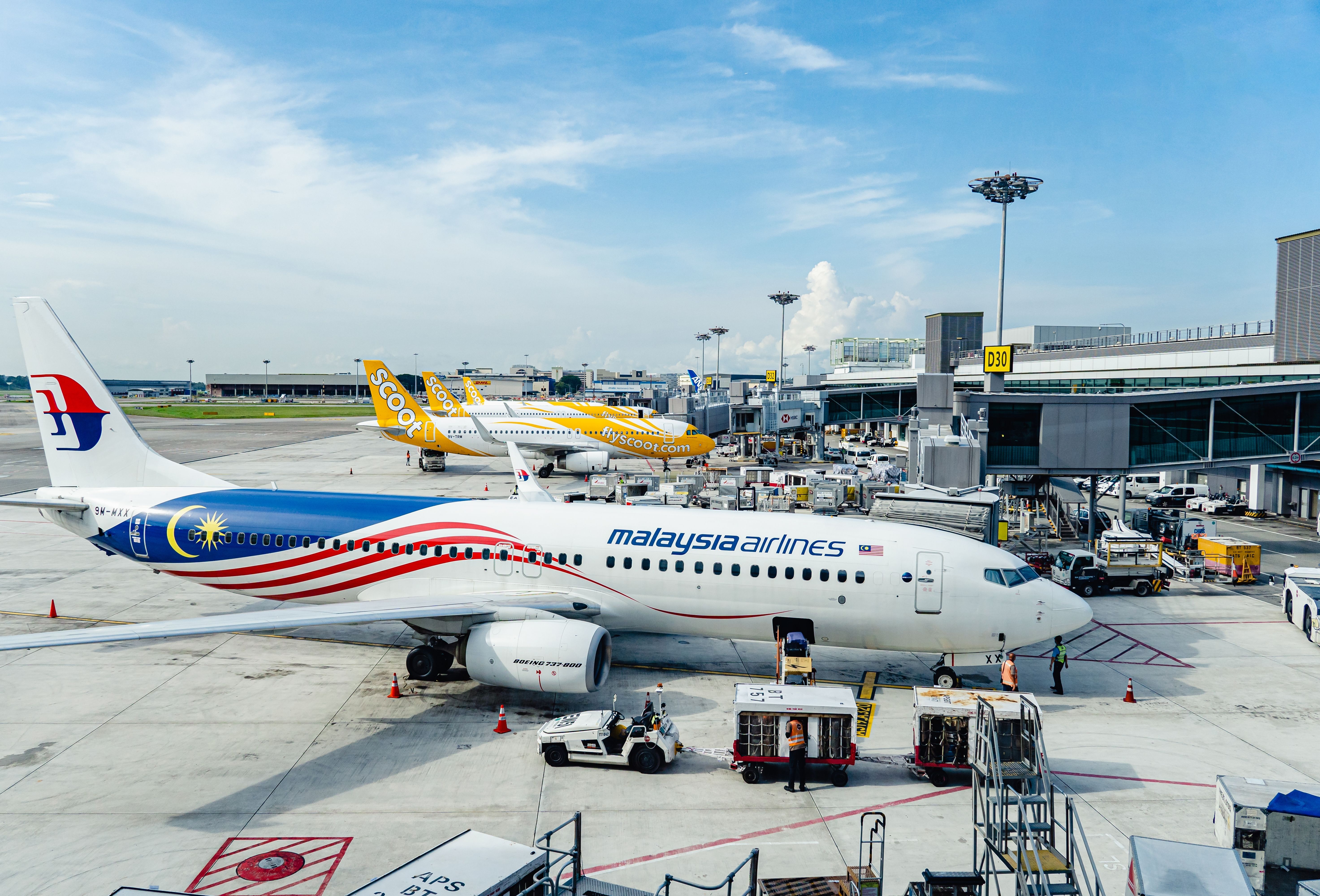 Scoot and Malaysia Airlines aircraft parked at Singapore Changi Airport.