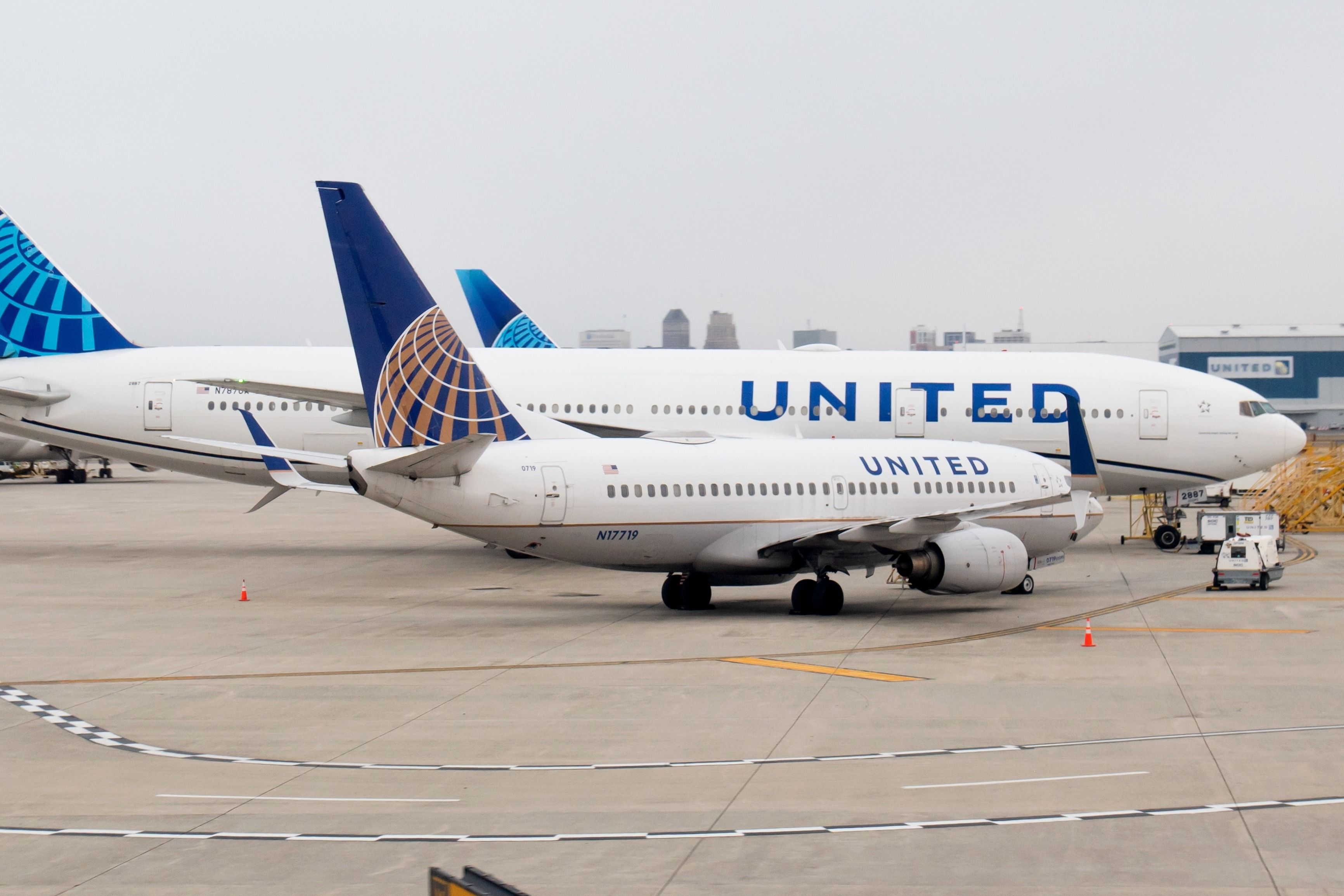 A United Airlines narrowbody parked next to a widebody at Newark Liberty International Airport.