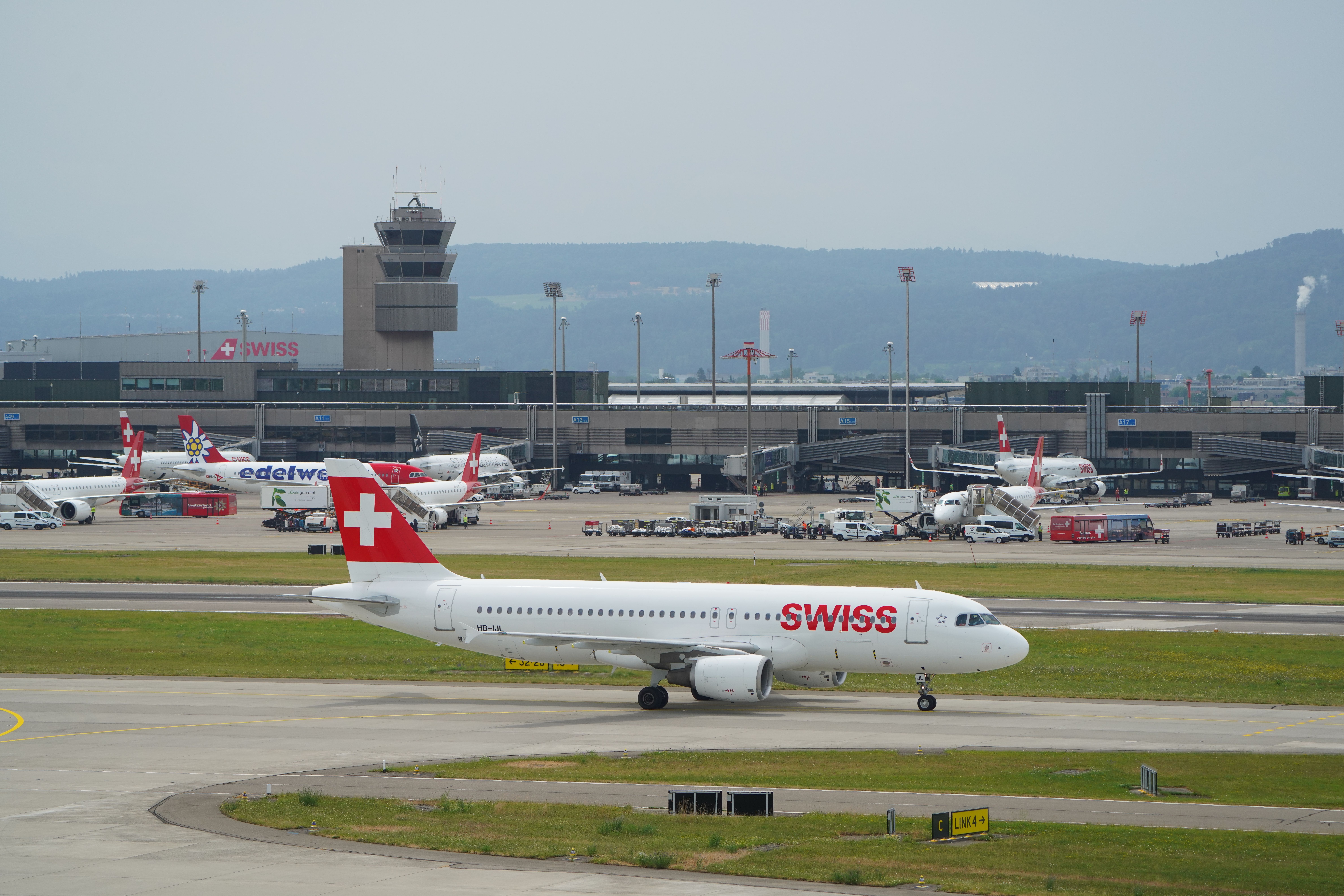 A SWISS aircraft on a taxiway, with many SWISS aircraft in the background.
