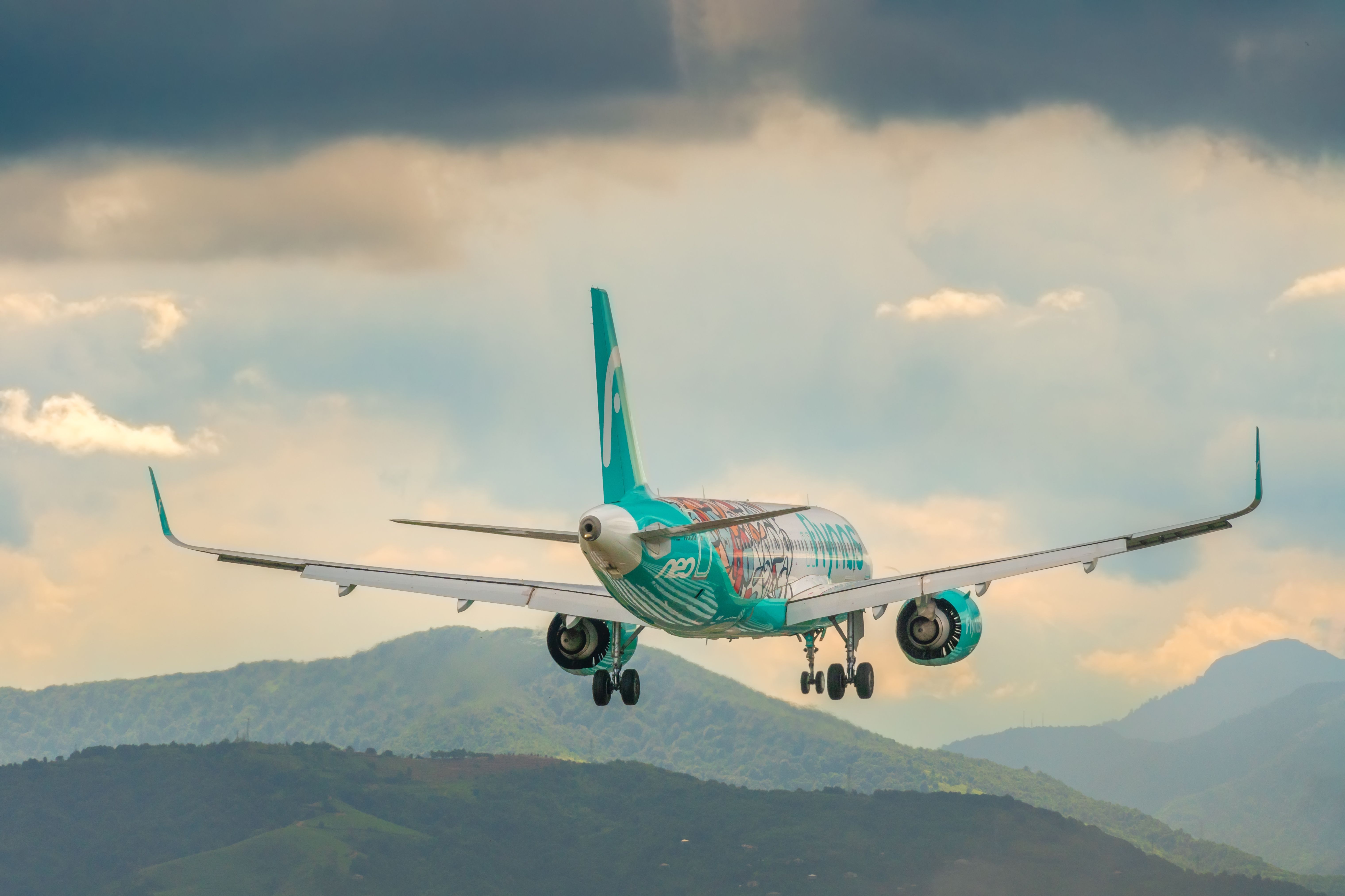 ​​​​​​​Close-up of the Flynas Airbus A320neo plane landing at Batumi International Airport against the backdrop of mountains