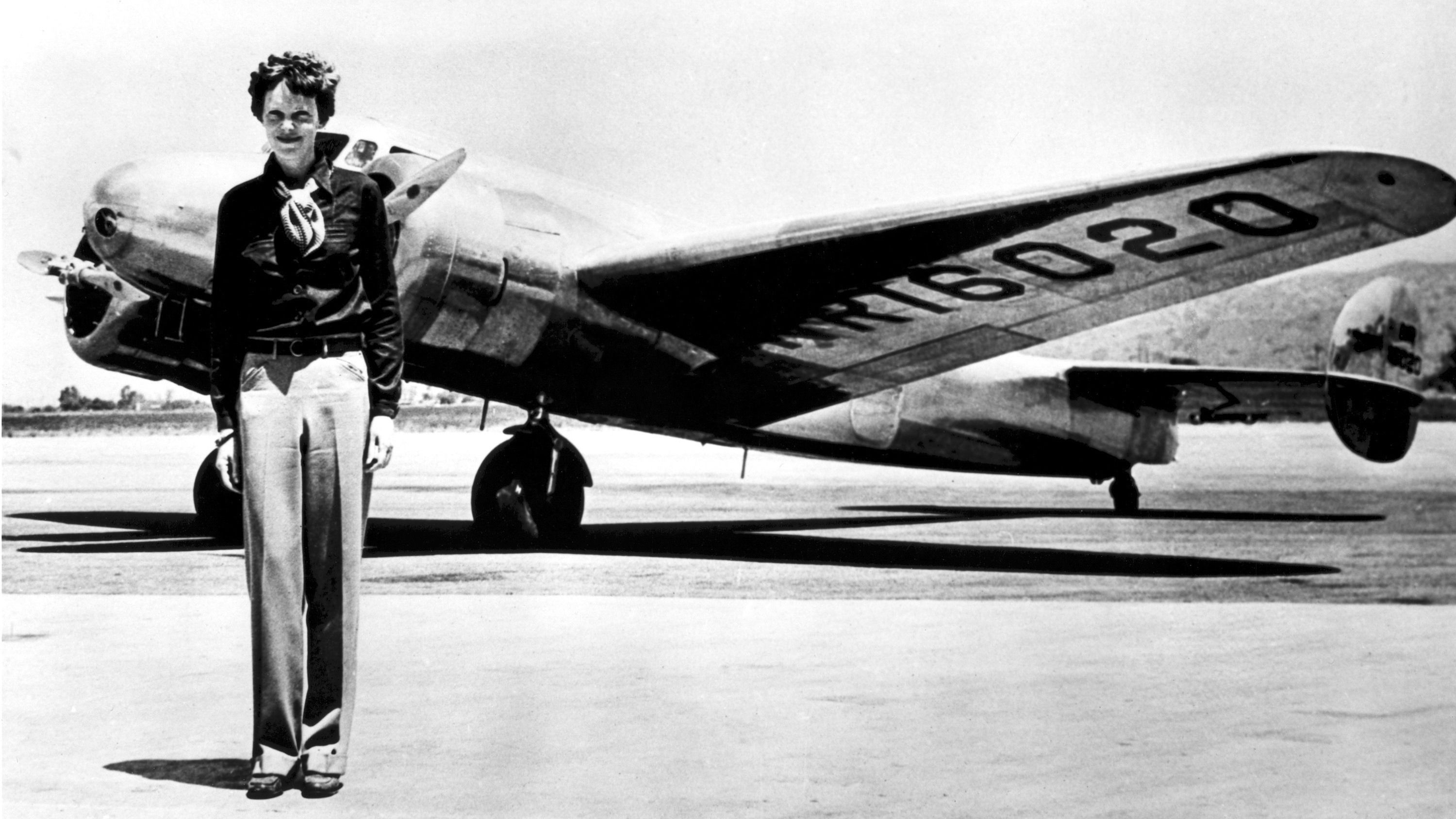 Amelia Earhart standing in front of the Lockheed Electra in which she disappeared.
