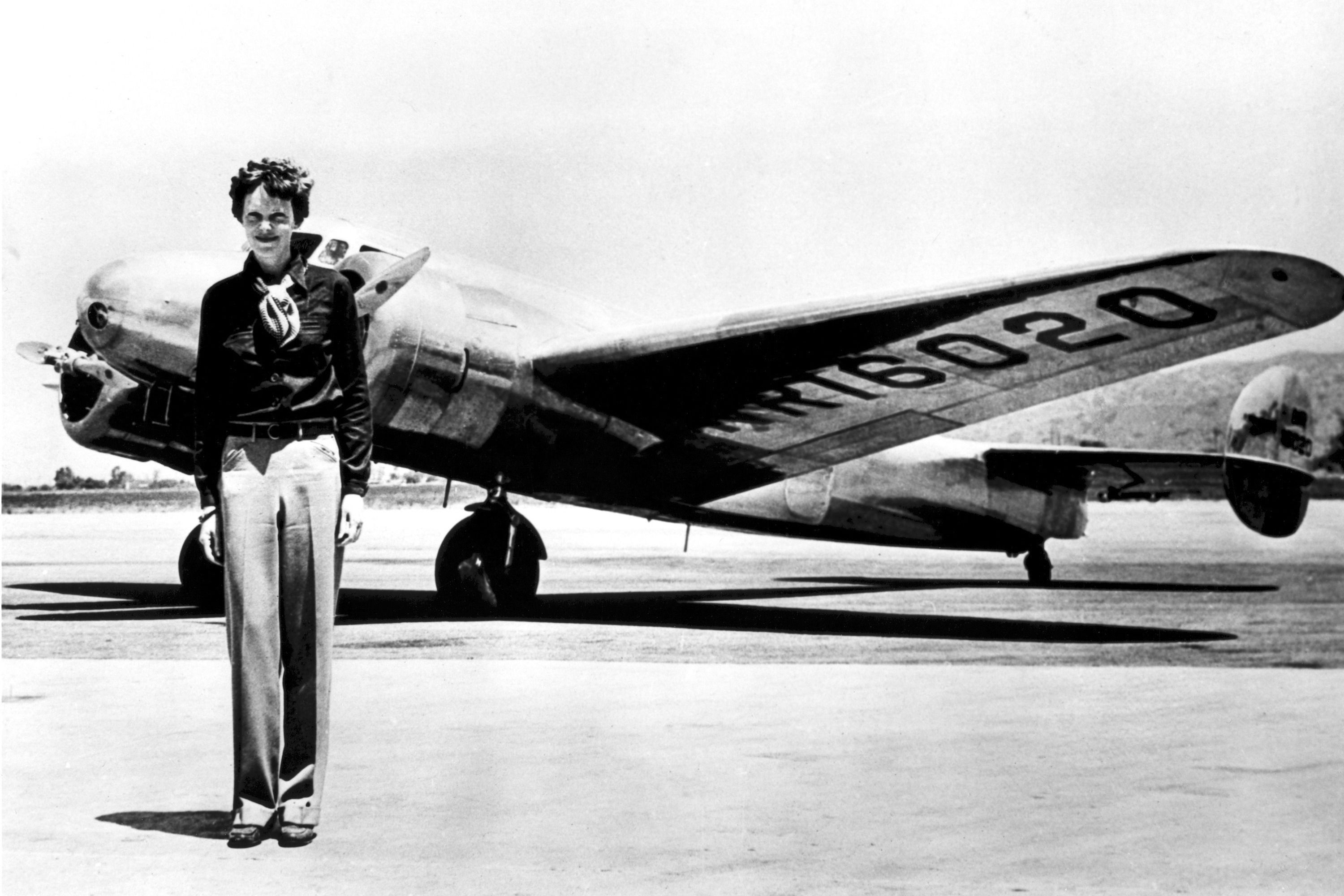 Amelia Earhart standing in front of the Lockheed Electra in which she disappeared.