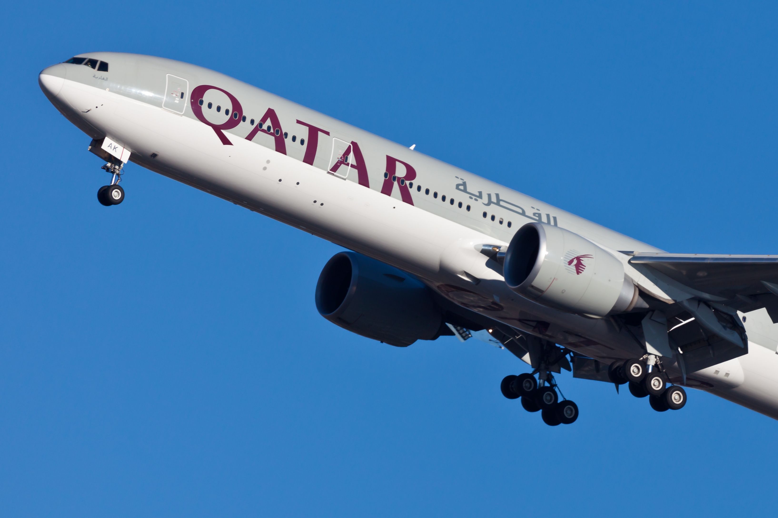A Qatar Airways Boeing 777 flying in the sky.