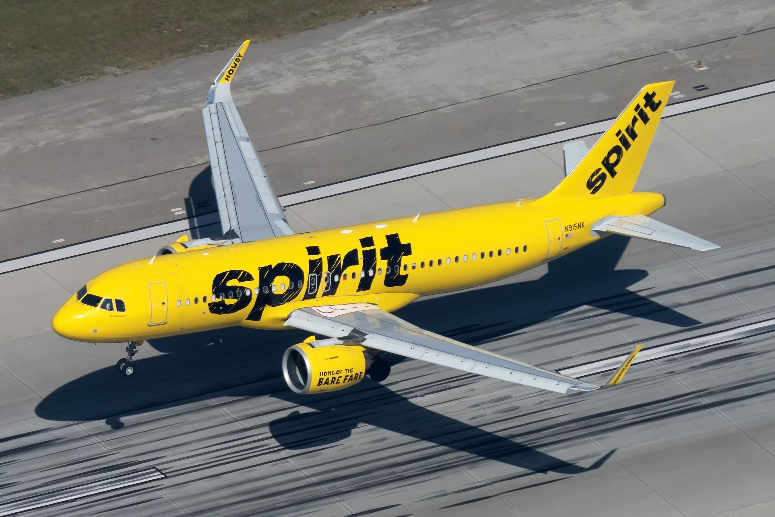 A Spirit Airlines Airbus aircraft just above a runway.