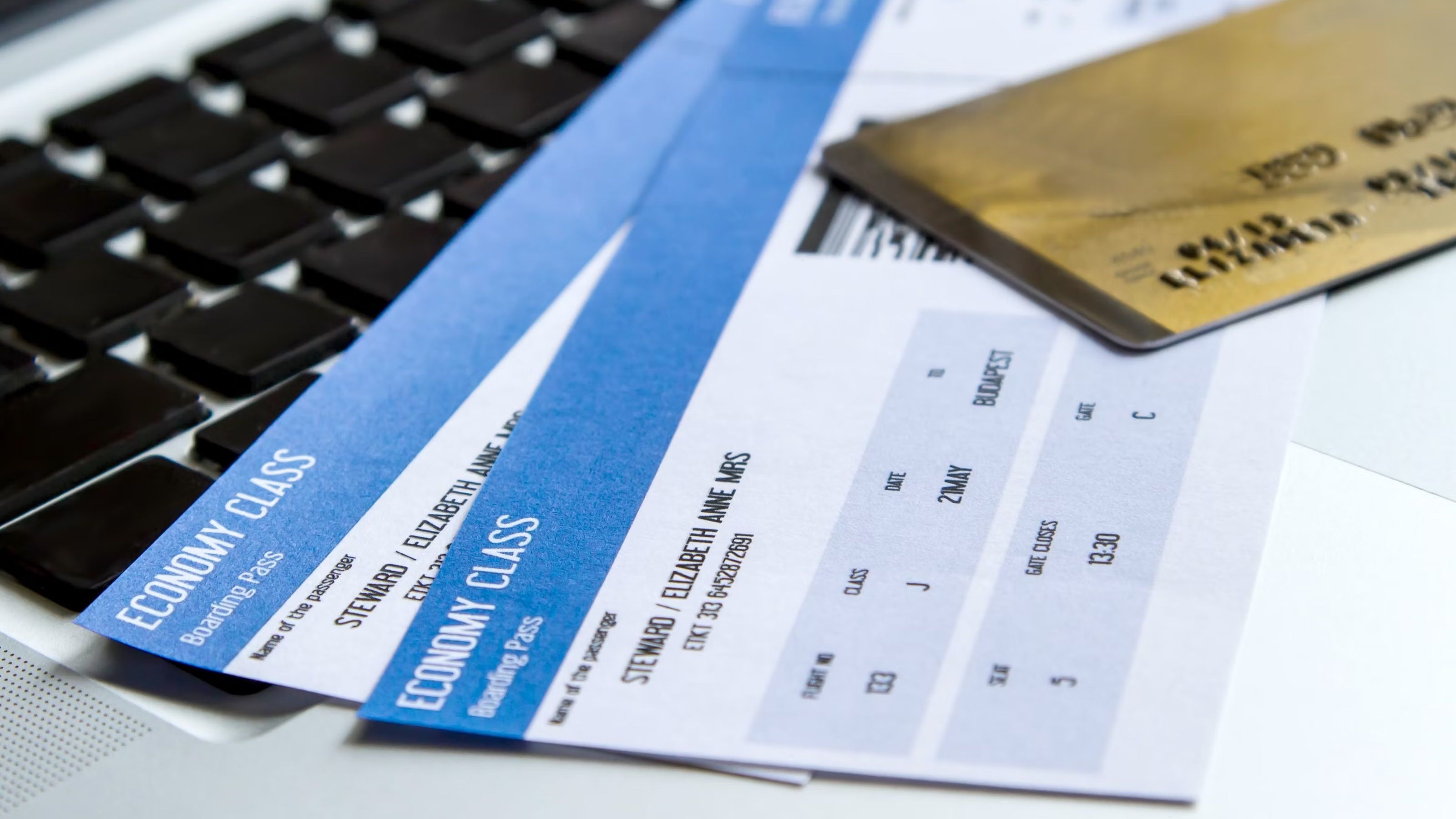 A generic photo of two airline tickets underneath a gold credit card.