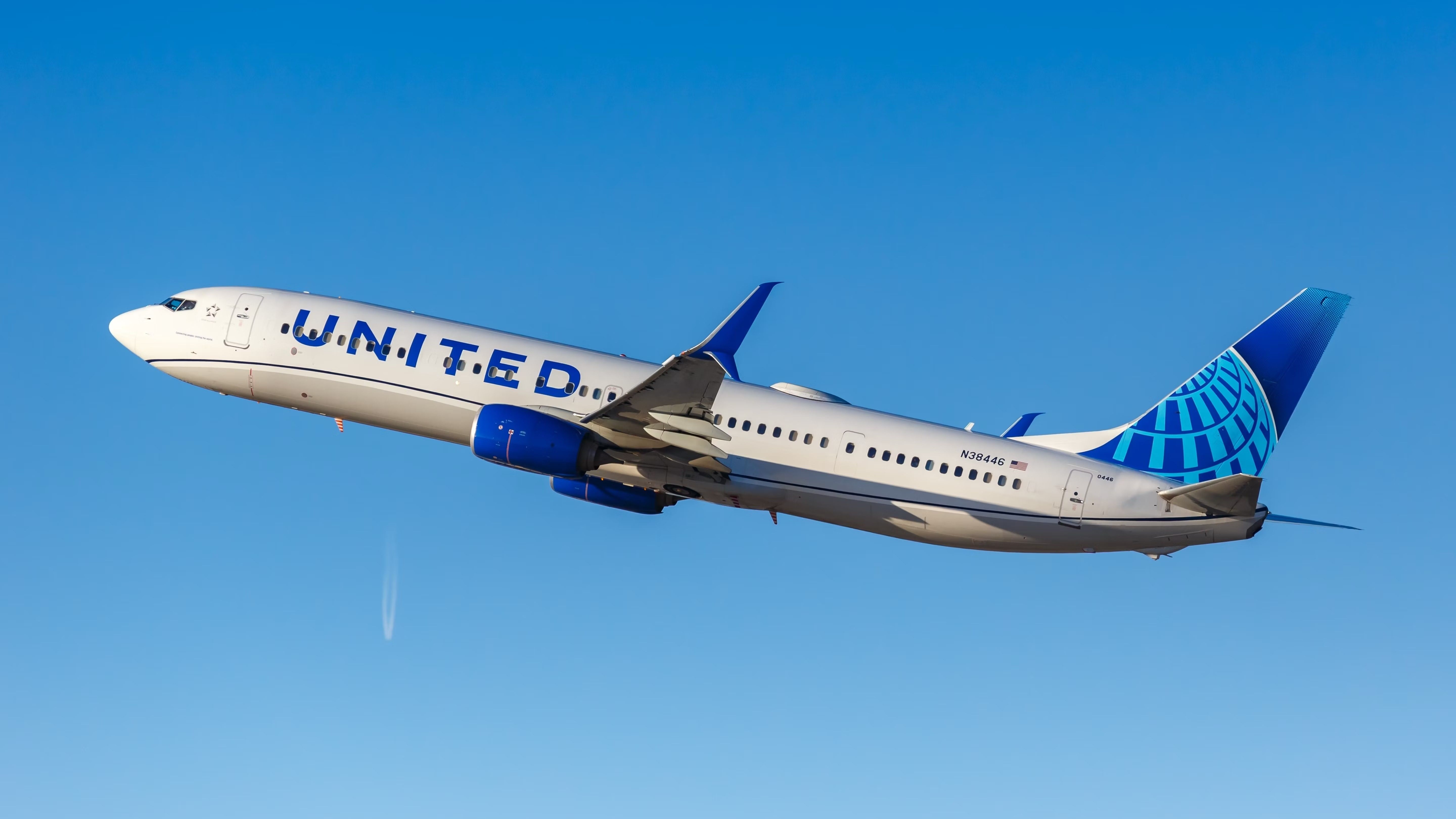 A United Airlines 737-900ER flying in the sky.