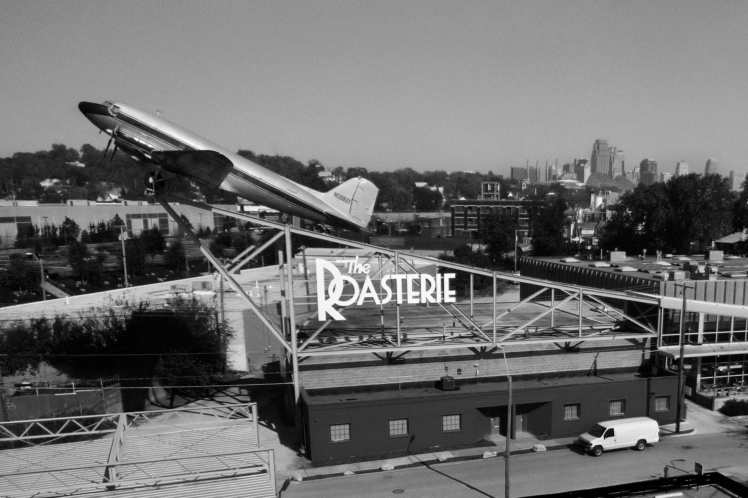 A photo of The Roasterie Coffee Factory with a Douglas DC-3 on top of it.