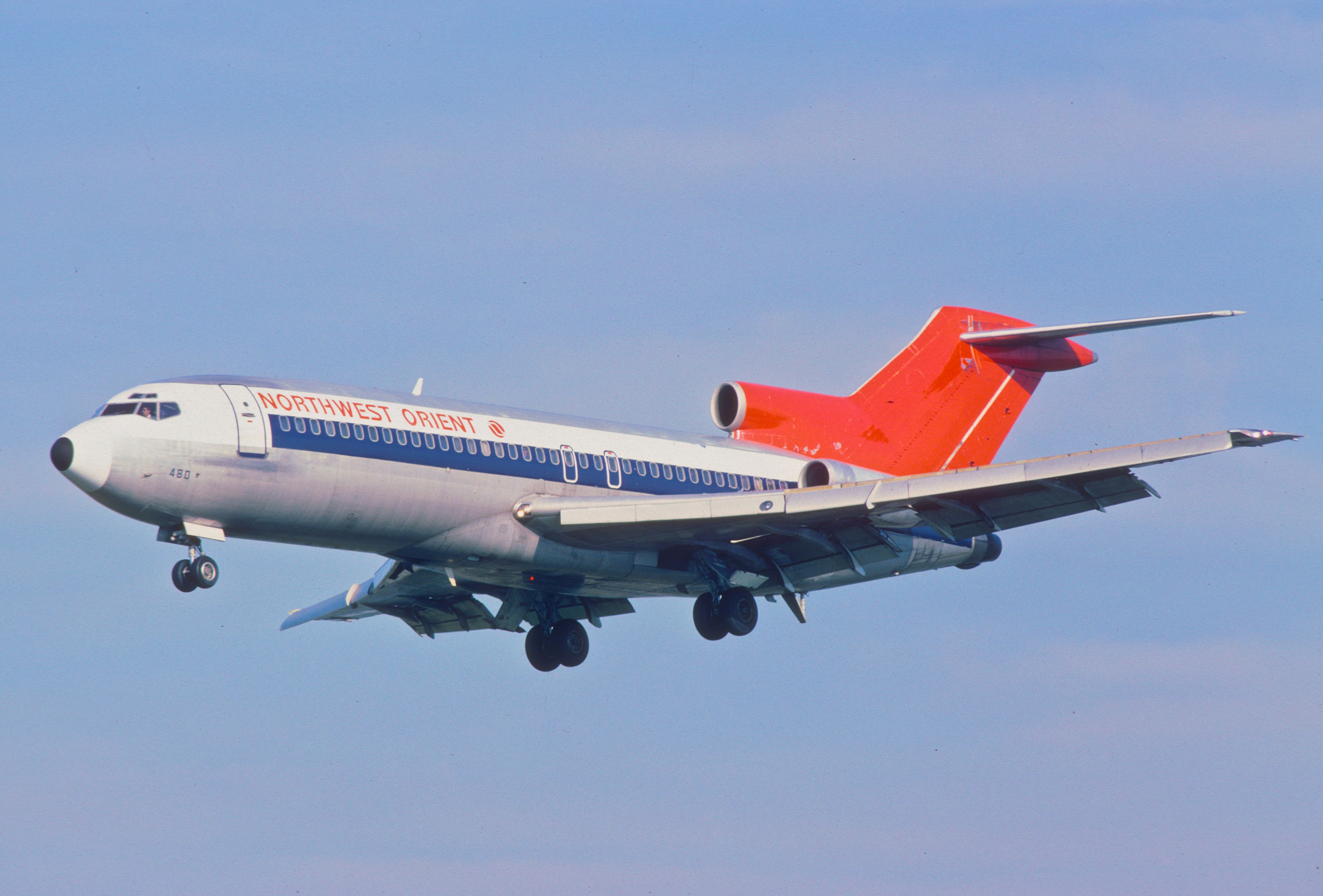 A Northwest Orient Airlines Boeing 727 flying in the sky.